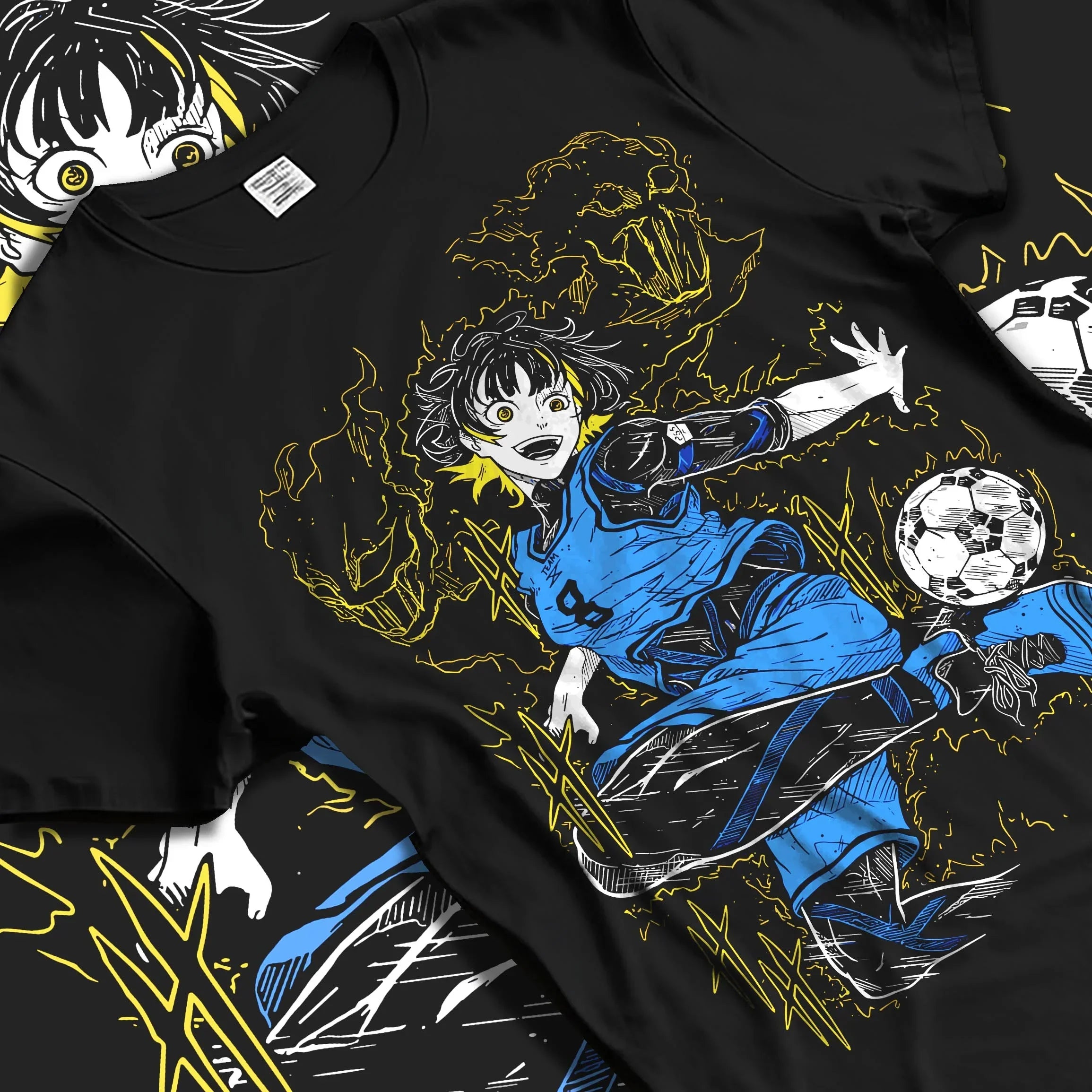 Black T-shirt laid flat featuring Blue Lock anime graphic of Bachira Meguru dribbling a soccer ball with electric yellow and blue aura effects.