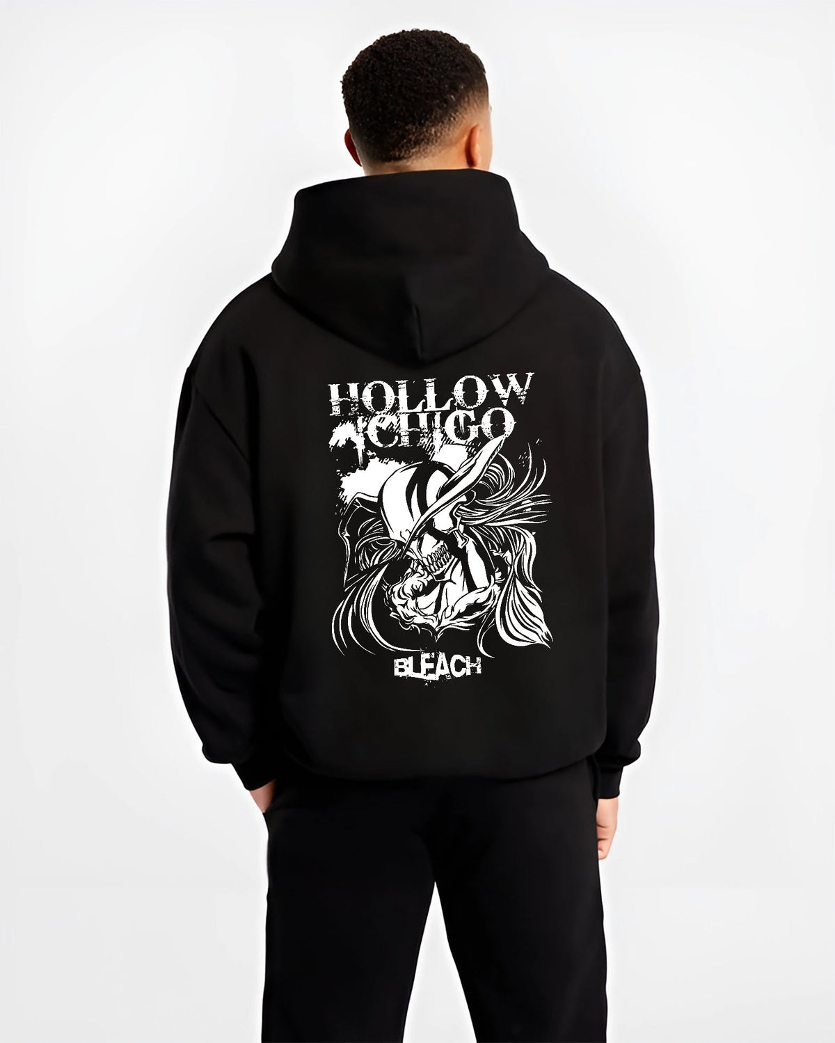 Black hoodie worn by a male model, back view, featuring Hollow Ichigo Bleach retro manga graphic with striking Japanese animation streetwear design.