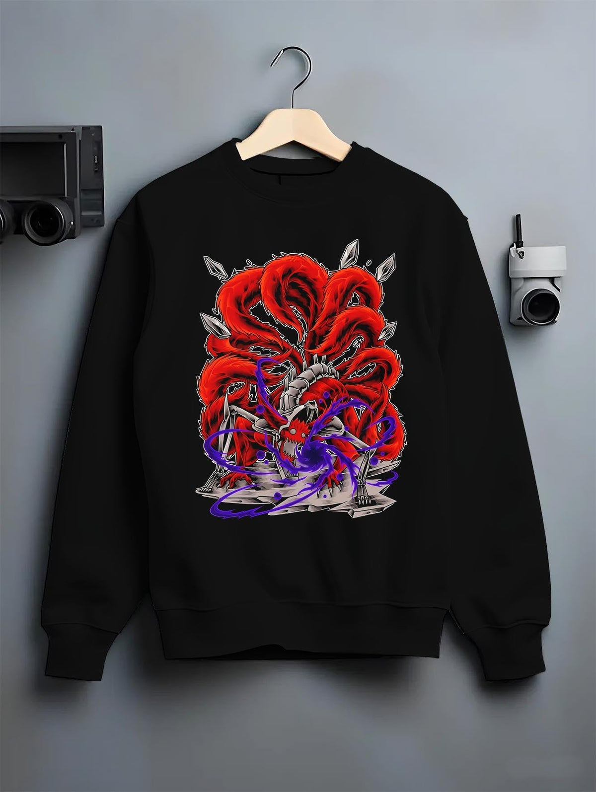 Black crewneck sweatshirt on a hanger against a grey wall, featuring Naruto Kurama Nine-Tails anime poster inspired design with bold chakra aura and retro manga style.