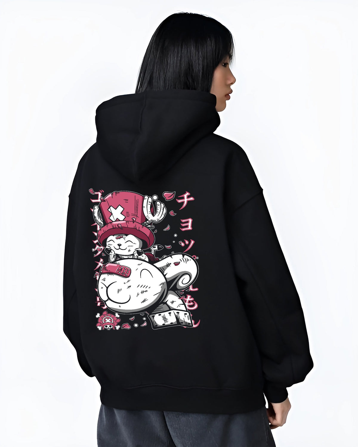 Black hoodie worn by a female model, back view, featuring One Piece Tony Tony Chopper playful manga-inspired pink design with bold Japanese text graphics.