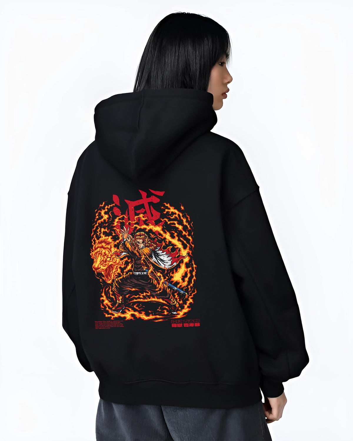 Black hoodie worn by a female model, back view, featuring Demon Slayer Rengoku anime poster inspired design with fiery retro manga graphic and bold flame sword stance.