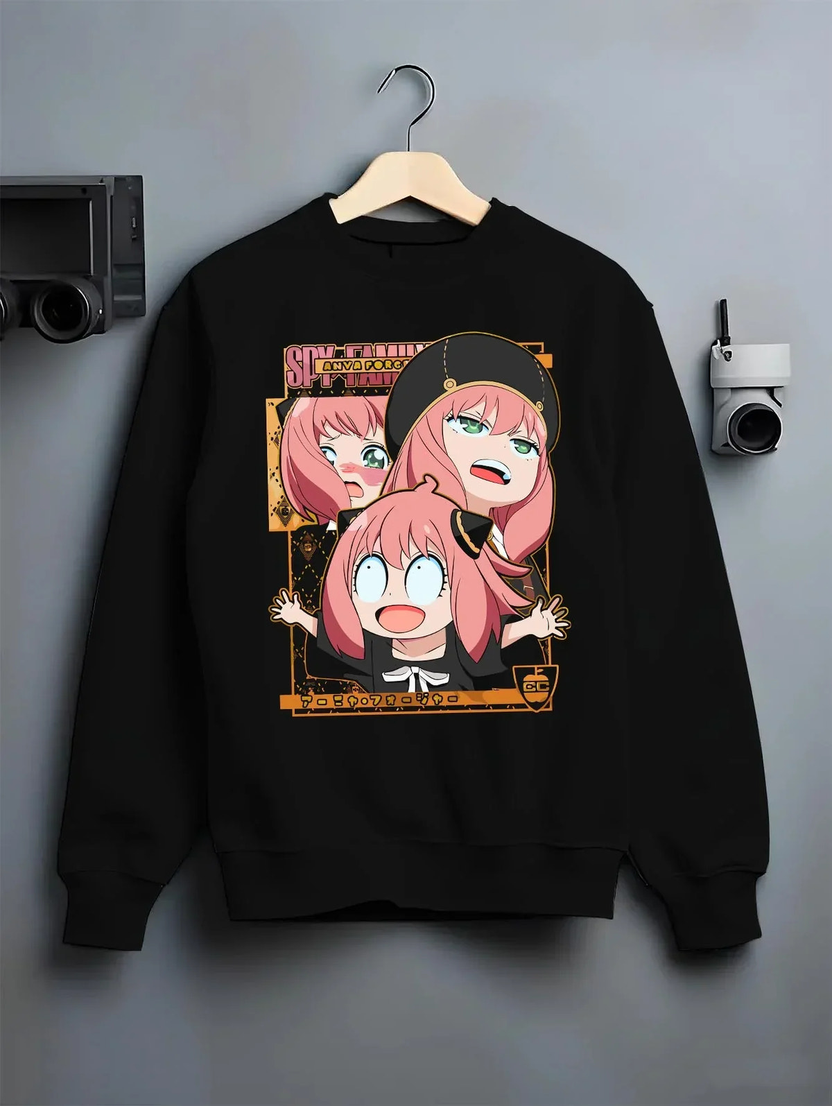 Black crewneck sweatshirt on hanger with Anya Forger Hoodie Spy x Family Funny Faces Expression graphic bold anime graphic.
