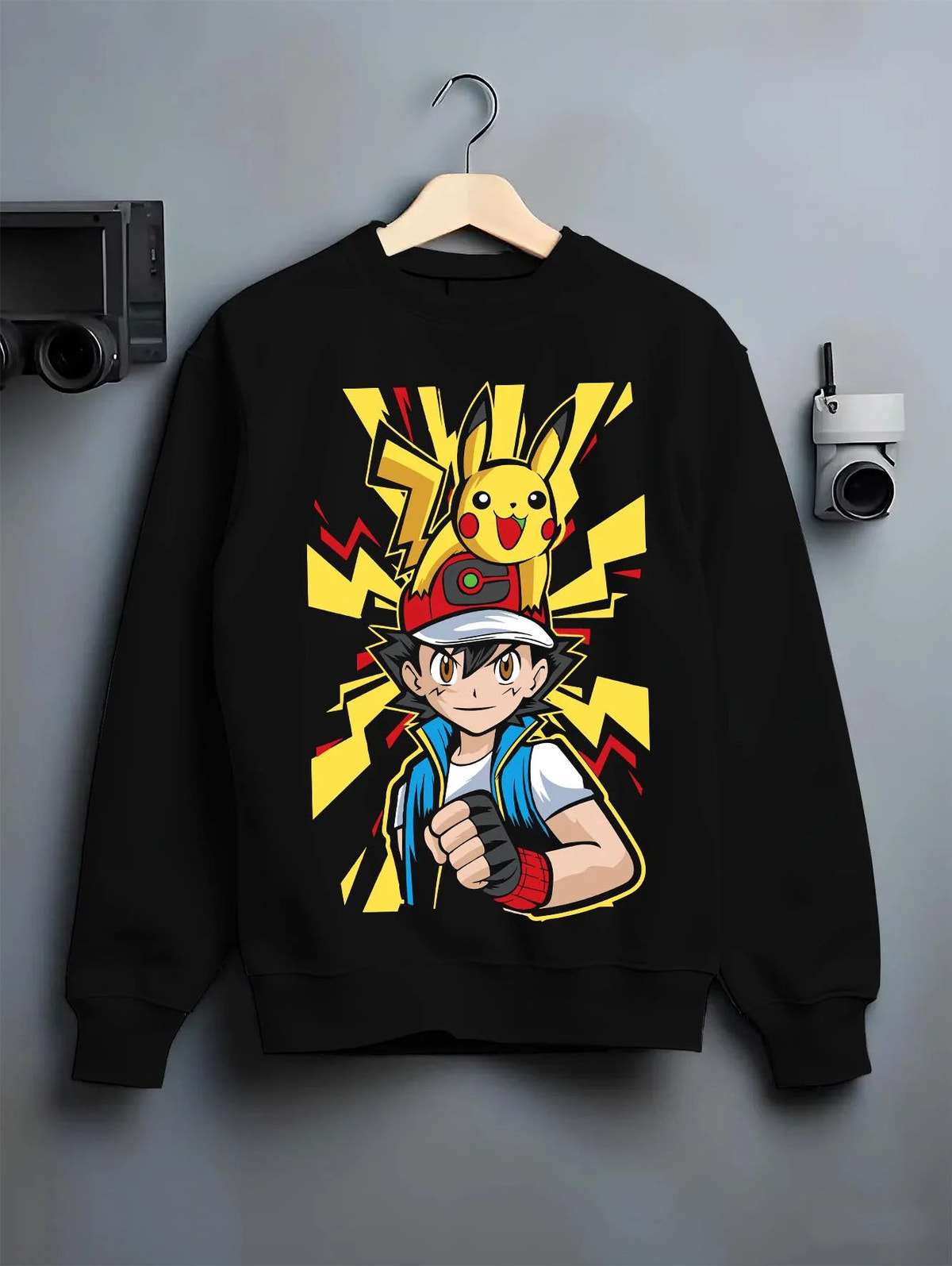 Black crewneck sweatshirt on hanger featuring Ash Ketchum and Pikachu Pokémon journey artwork.