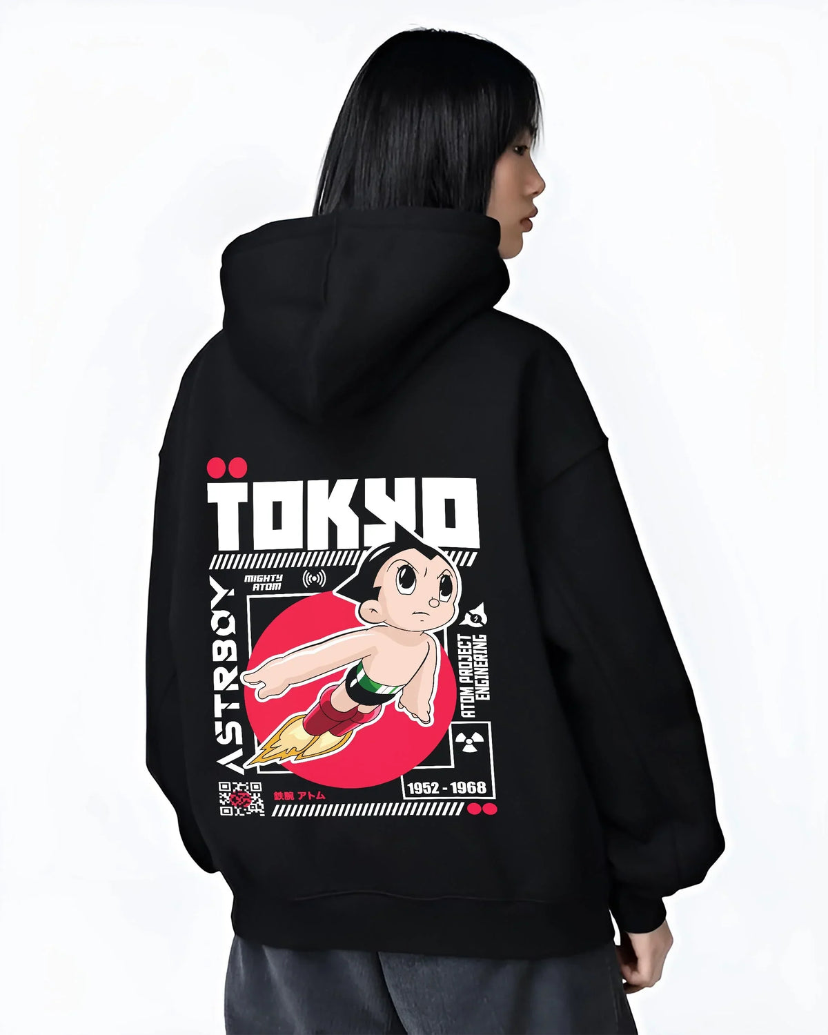 Black hoodie worn by female model, back view with Astro Boy Hoodie Retro Tokyo Anime Robot Hero Poster graphic bold anime graphic.