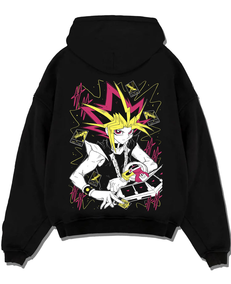 Black hoodie laid flat featuring Atem and Dark Magician Yu-Gi-Oh duel spirit artwork with bold anime graphic print.