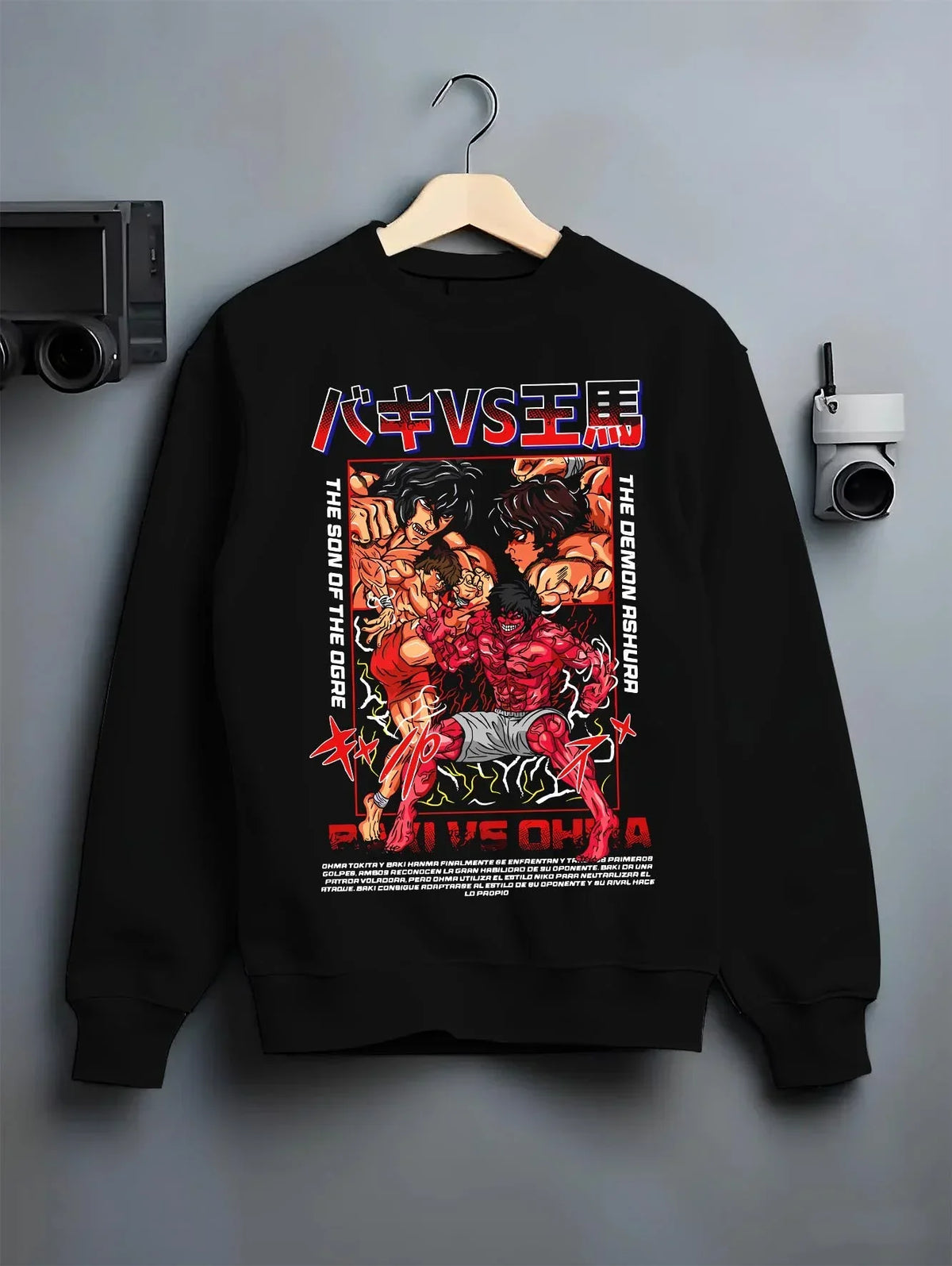 Black crewneck sweatshirt on hanger with Baki vs Ohma Hoodie Baki Hanma Kengan Ashura Showdown graphic premium wear.
