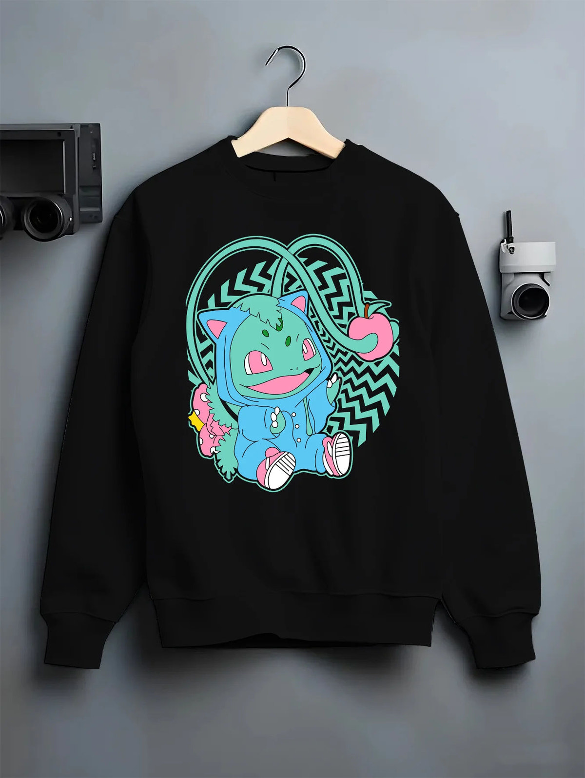 Black crewneck sweatshirt on hanger showing Bulbasaur from Pokémon: cute stylised illustration