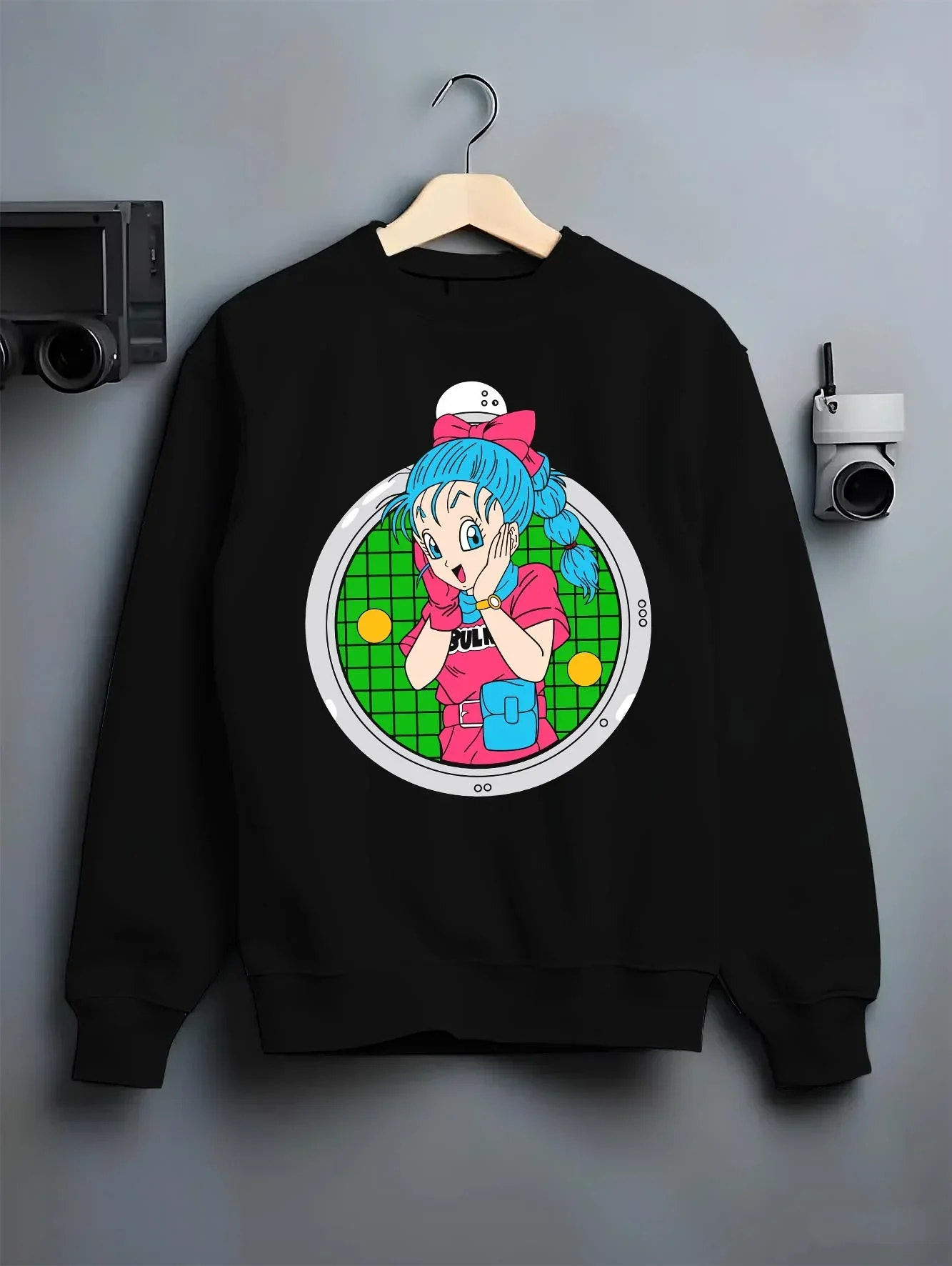 Black crewneck sweatshirt on hanger with Bulma Capsule Corp Hoodie Dragon Ball Z Retro Anime graphic streetwear graphic.