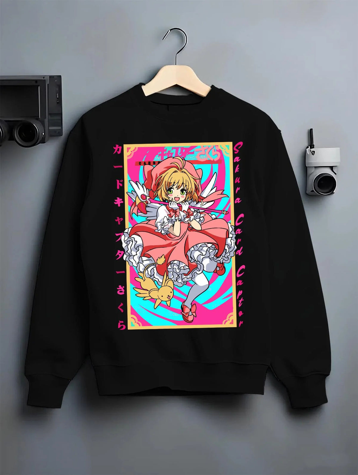 Black crewneck sweatshirt on hanger featuring Cardcaptor Sakura Clow Master artwork.