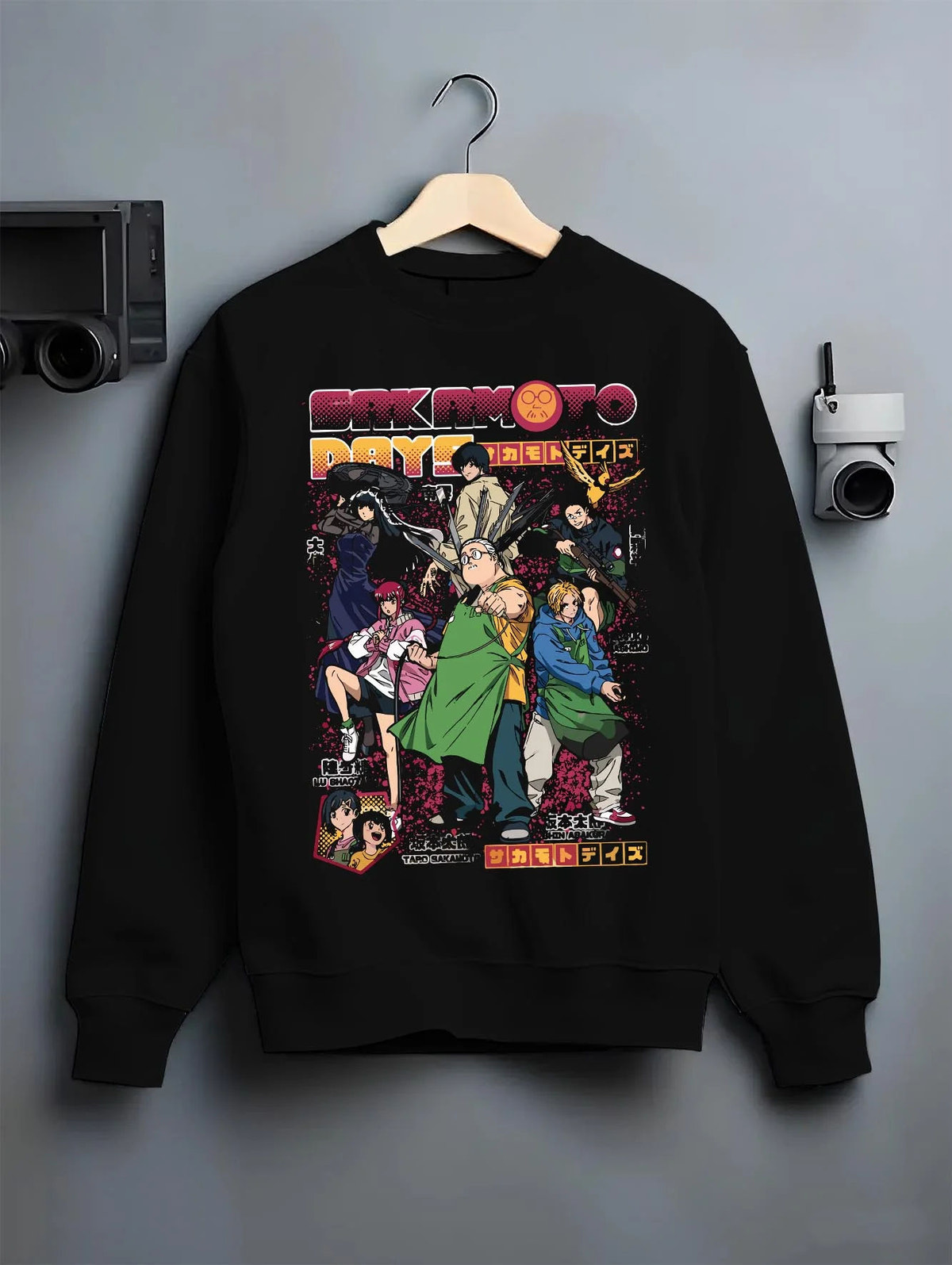 Black crewneck sweatshirt on hanger featuring Sakamoto Days cast group action artwork.