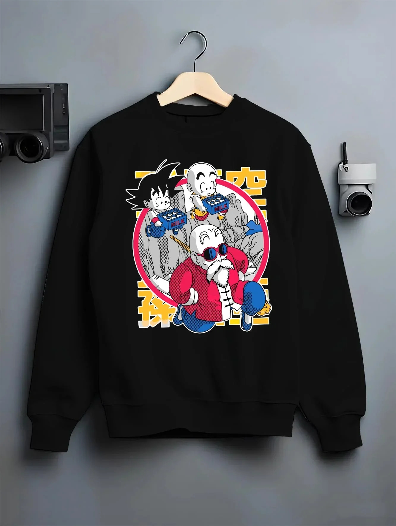 Black crewneck sweatshirt on hanger with Dragon Ball Hoodie Krillin Retro Training White Gi graphic bold anime graphic.
