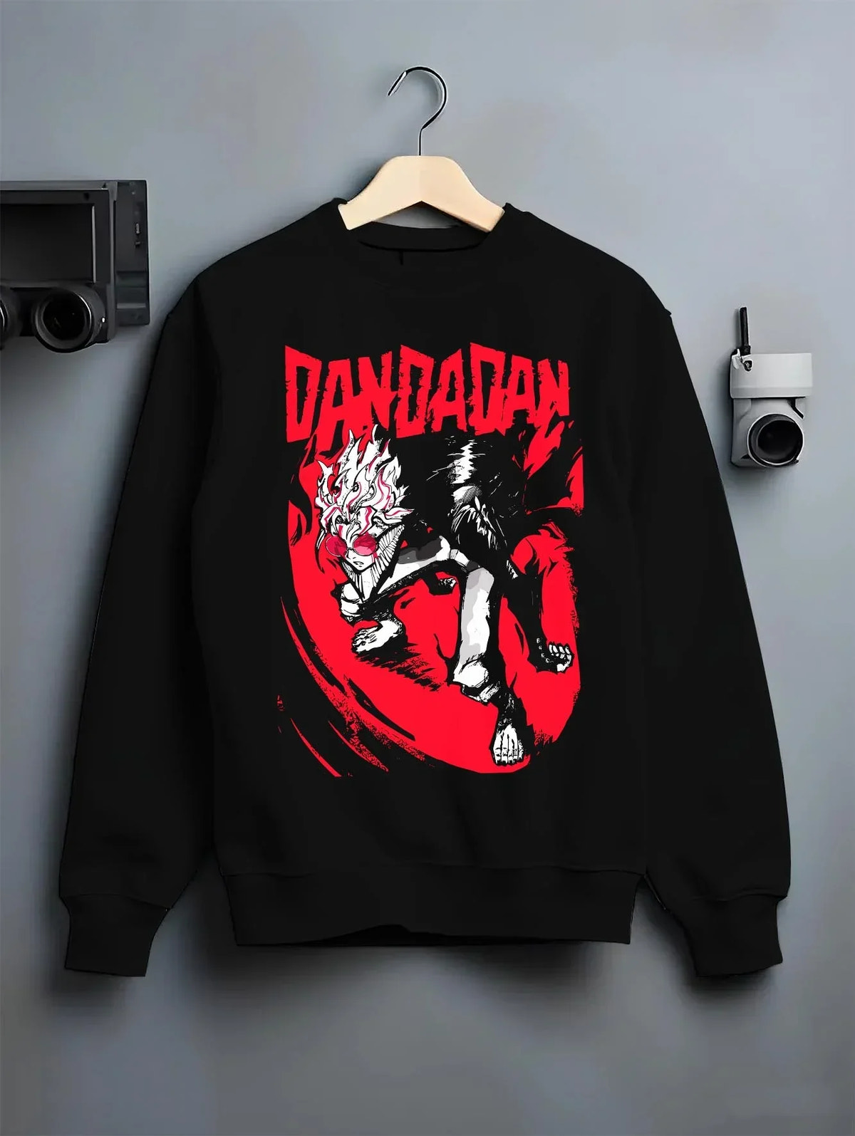 Black crewneck sweatshirt on hanger with Dandadan Hoodie Retro Anime Occult Spirit Adventure graphic streetwear graphic.