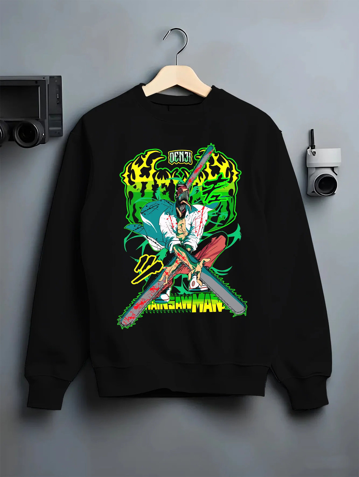 Black crewneck sweatshirt on hanger showing Chainsaw Devil / Denji from Chainsaw Man: neon green chainsaw sword pose