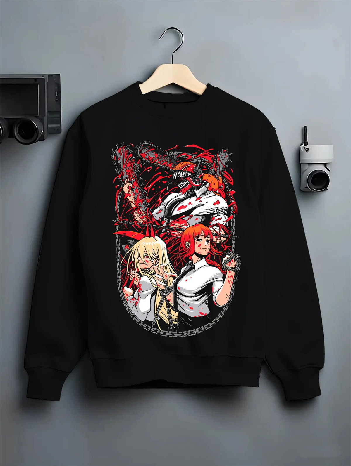 Black crewneck sweatshirt on hanger showing Denji and Power from Chainsaw Man: Chainsaw Devil ensemble, circular composition