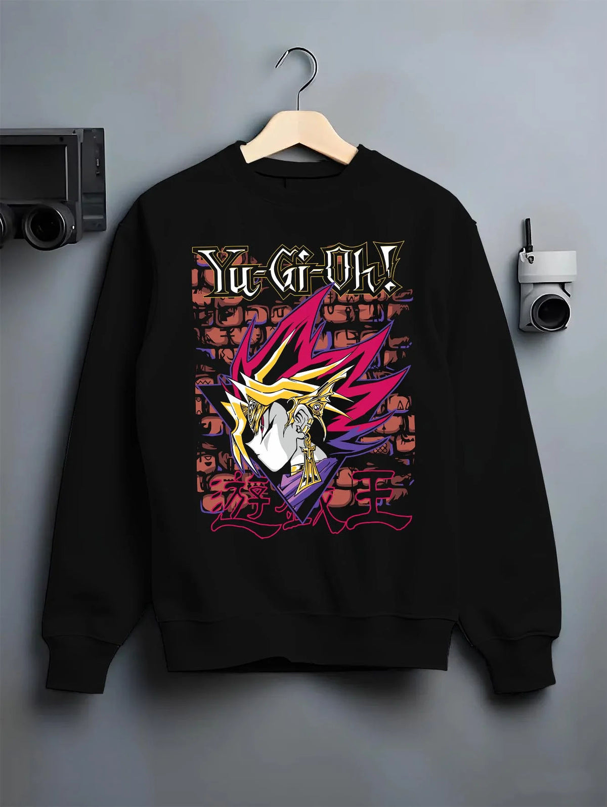 Black crewneck sweatshirt on hanger featuring Dark Magician Yu-Gi-Oh duel monster artwork.