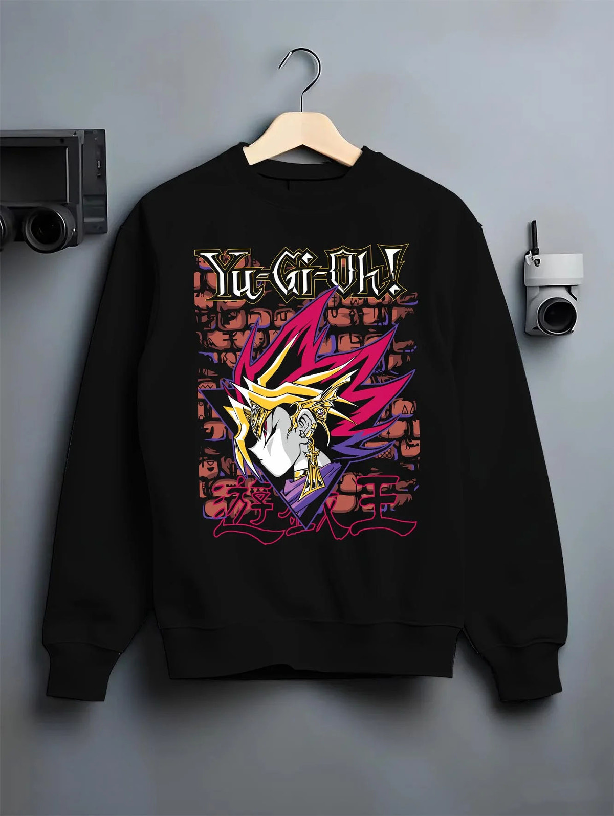 Black crewneck sweatshirt on hanger featuring Dark Magician Yu-Gi-Oh duel monster artwork.