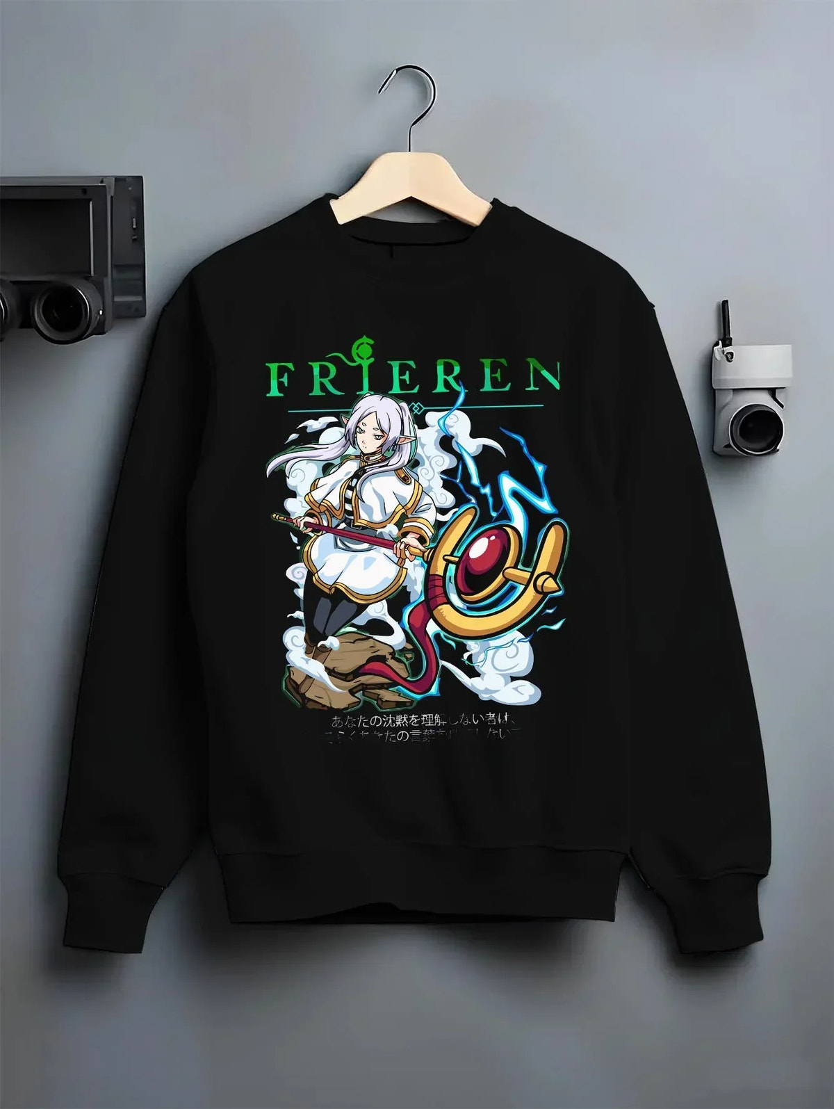 Black crewneck sweatshirt on hanger with Frieren Hoodie Beyond Journey’s End Magic Pose graphic streetwear graphic.