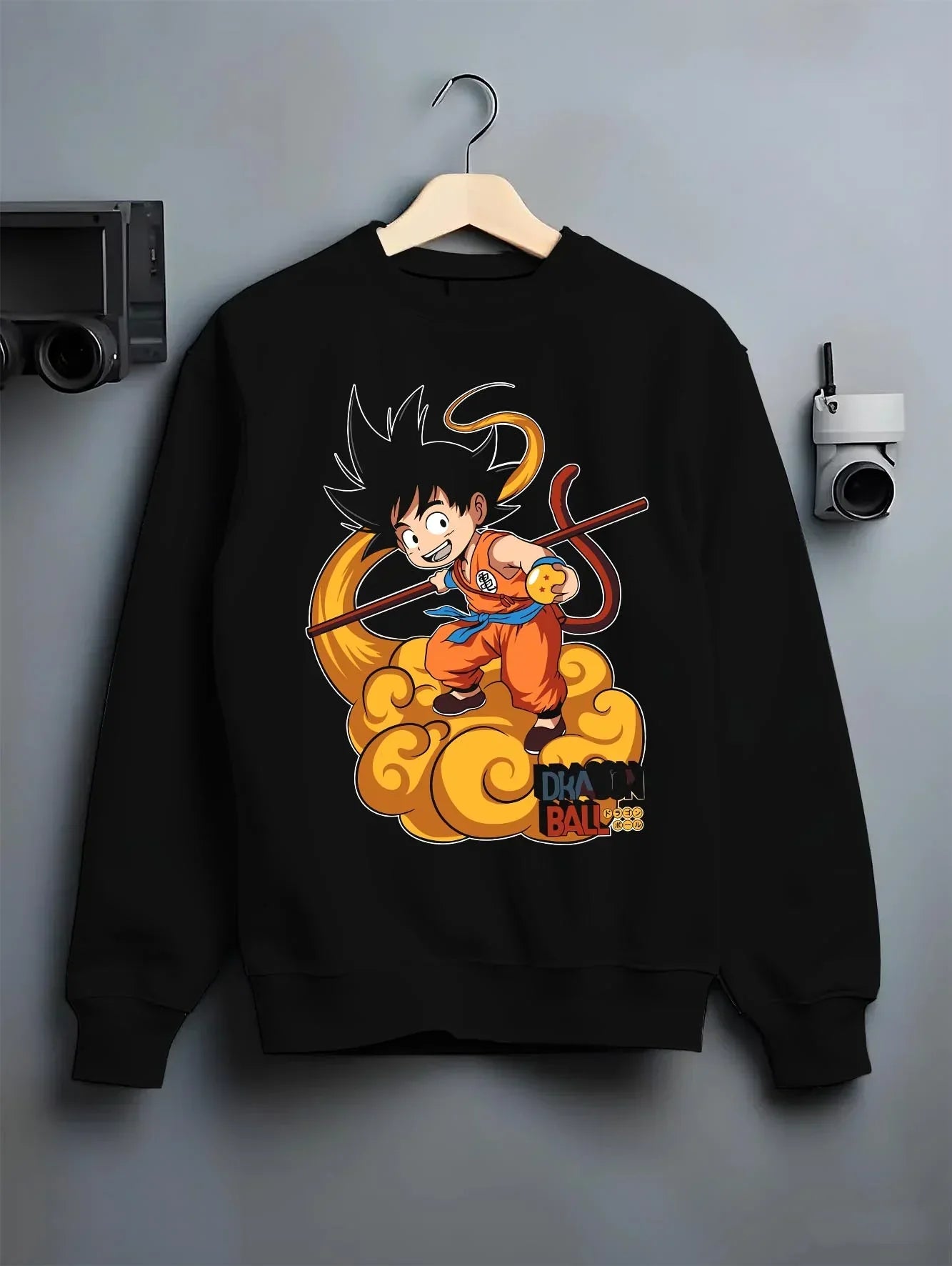 Black crewneck sweatshirt on hanger with Dragon Ball Z Hoodie Kid Goku Nimbus Jumper graphic bold anime graphic.