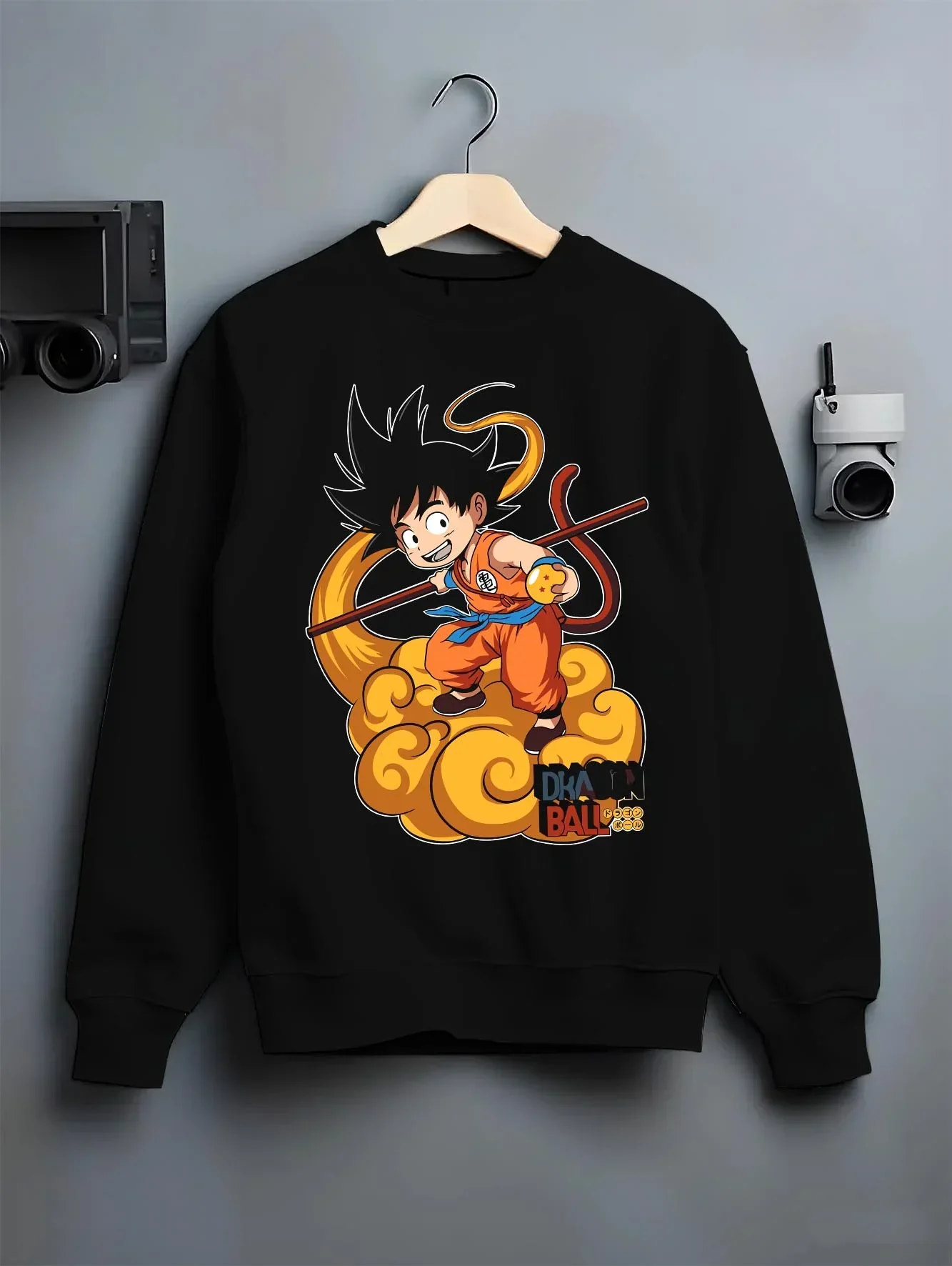 Black crewneck sweatshirt on hanger with Dragon Ball Z Hoodie Kid Goku Nimbus Jumper graphic bold anime graphic.
