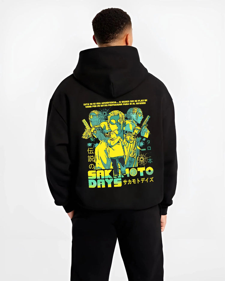 Black hoodie worn by male model from the back featuring Sakamoto Days trio action artwork.