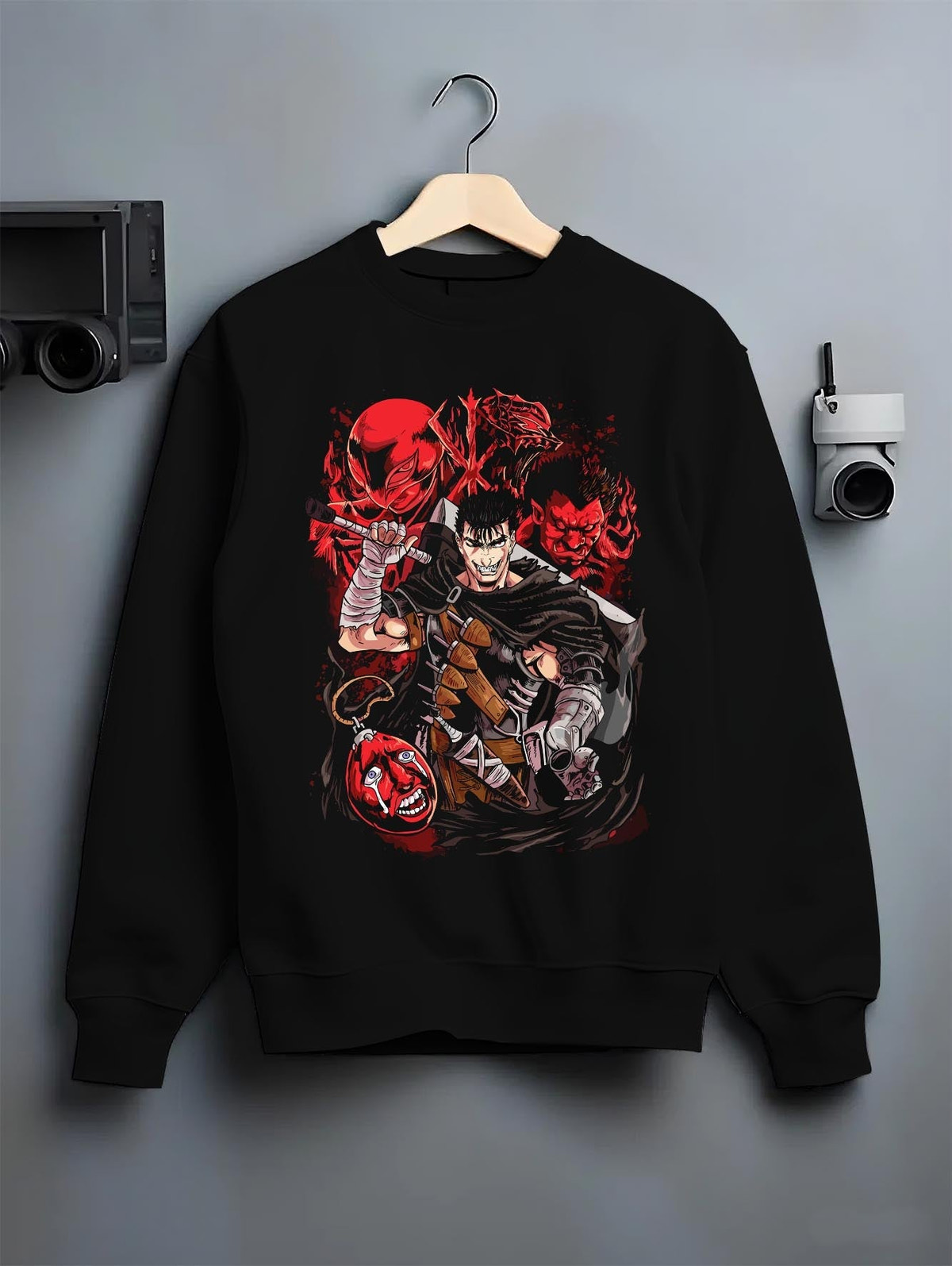 Black crewneck sweatshirt on a hanger against a grey wall, featuring Berserk Guts anime poster inspired back graphic with Apostles in dark manga style.