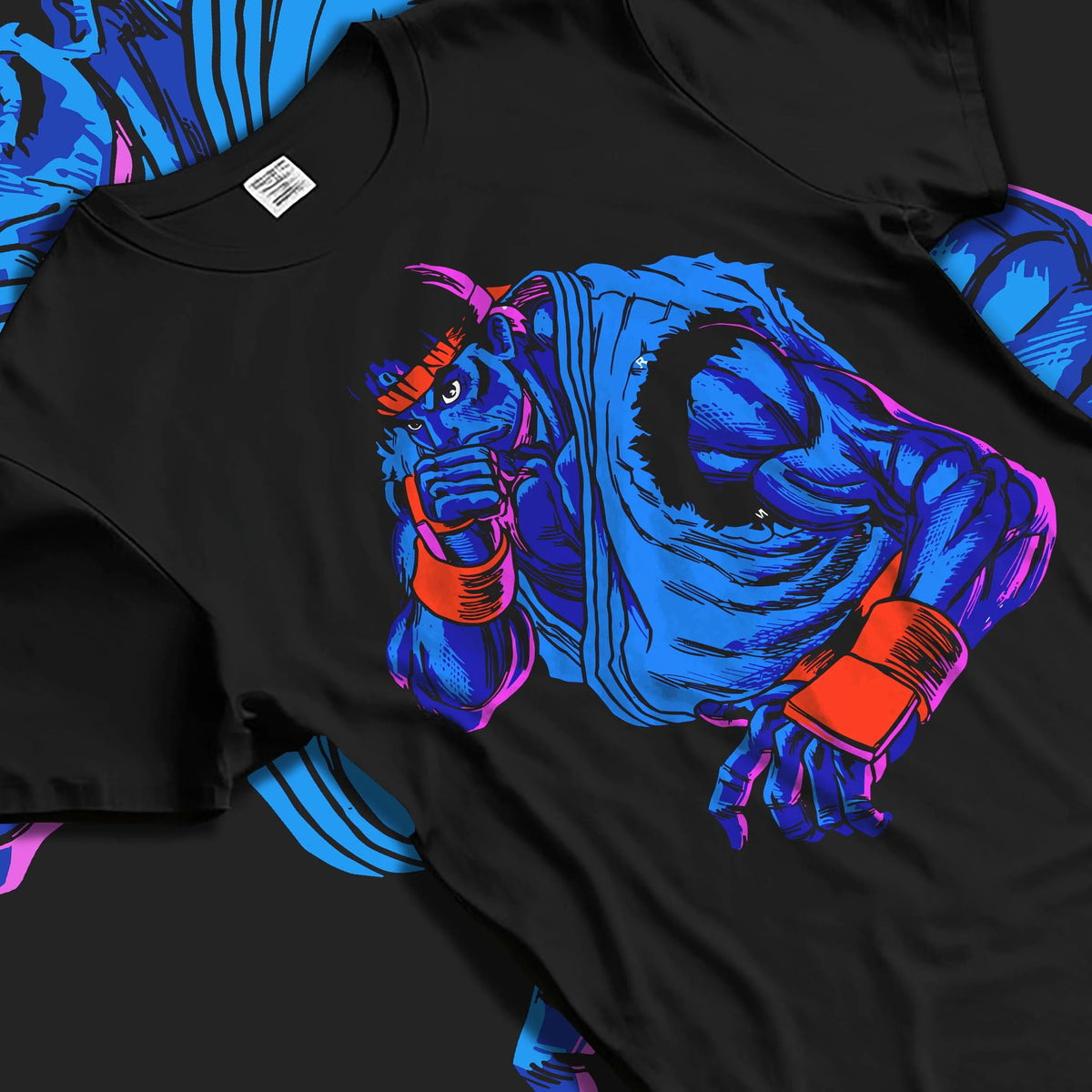 Black T-shirt laid flat with natural folds featuring Ryu blue gi Hadouken battle artwork.