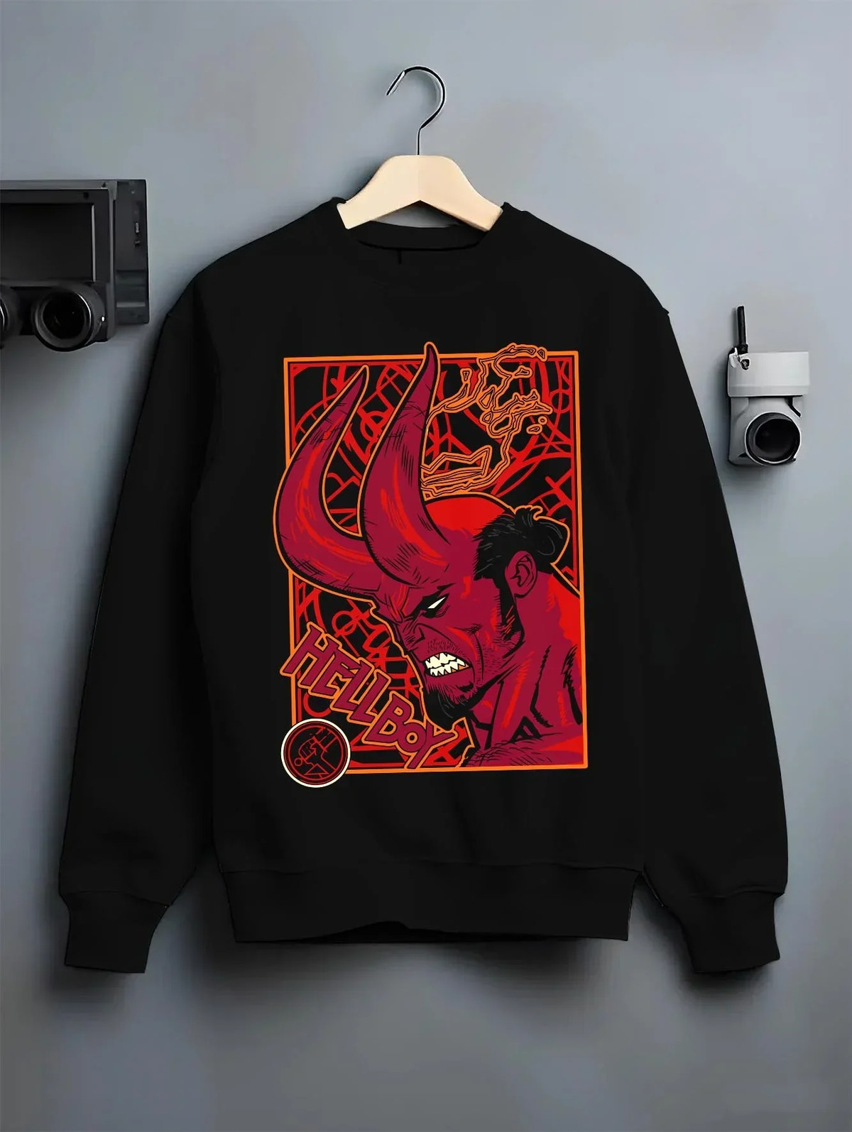 Black crewneck sweatshirt on hanger with Hellboy Hoodie Classic Comic Dark Hero Jumper graphic bold anime graphic.
