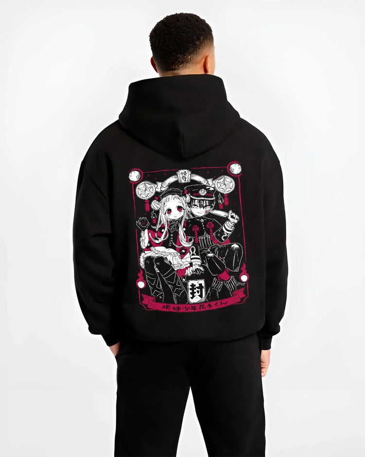 Black hoodie worn by male model, back view, showing Toilet-Bound Hanako-kun artwork of Hanako-kun and Nene Yashiro anime poster inspired design.