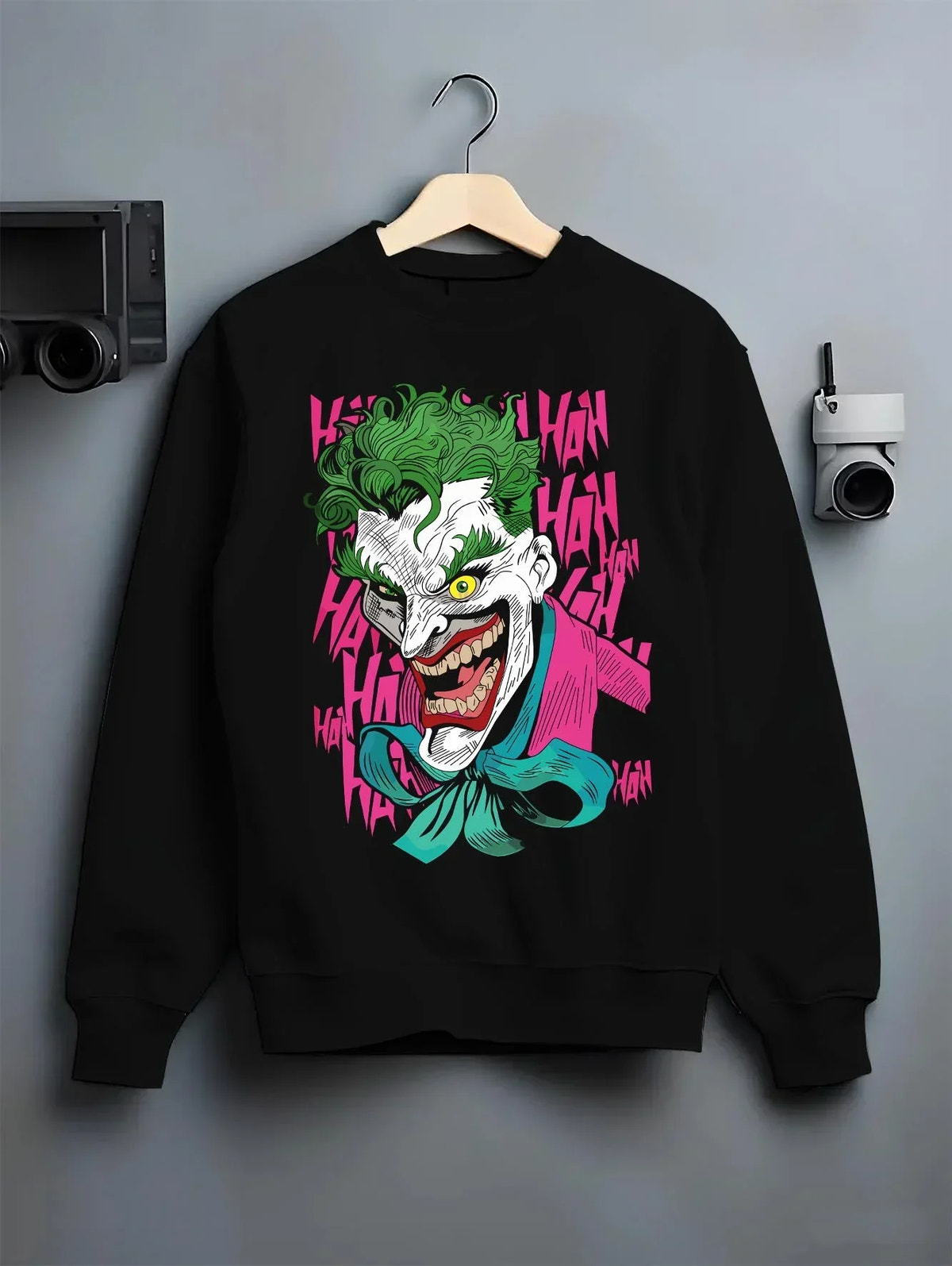 Black crewneck sweatshirt on hanger with Joker Hoodie Gotham Anime Inspired Laughing Villain Design graphic bold anime graphic.