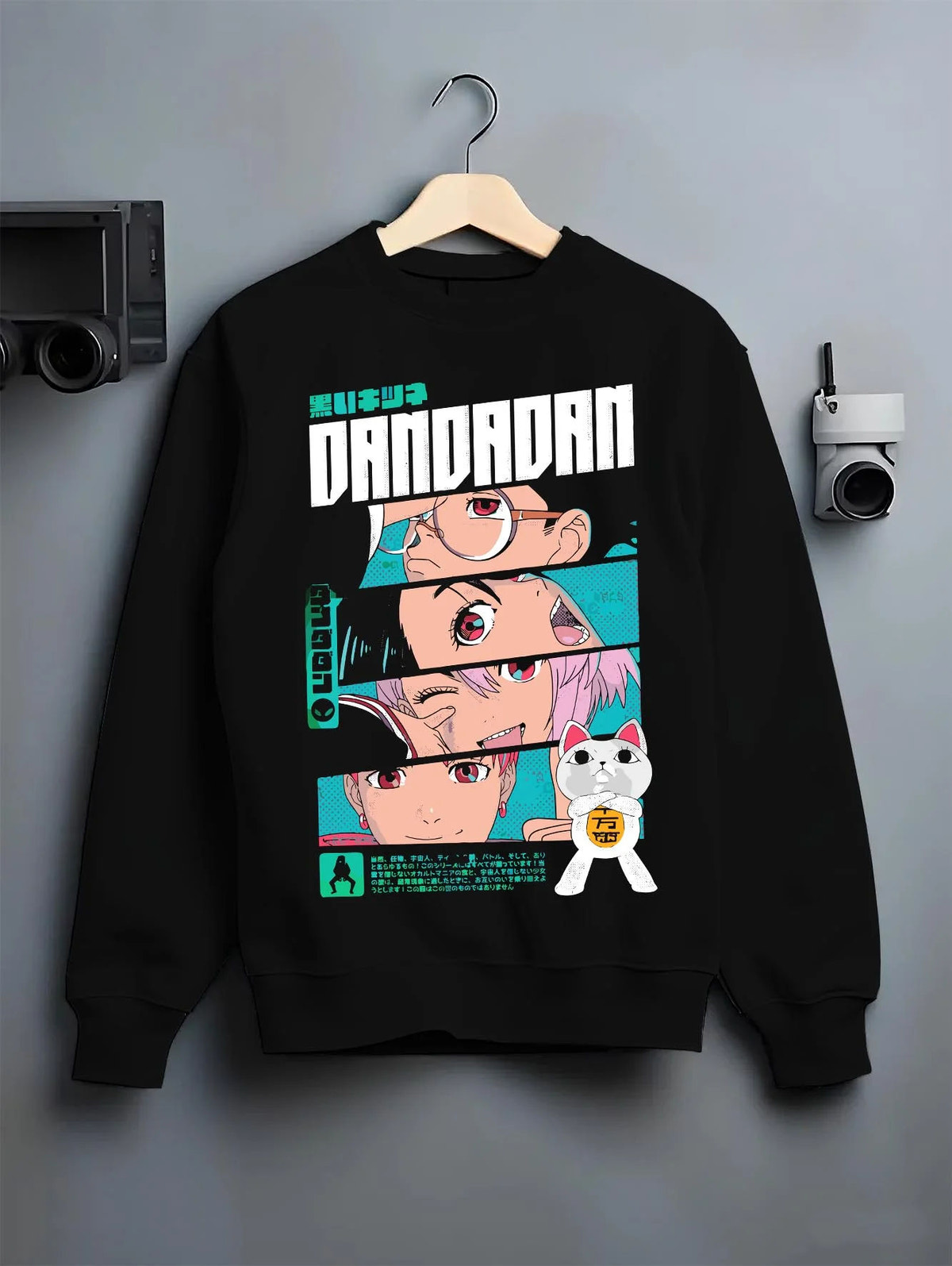 Black crewneck sweatshirt on hanger showing Dandadan ensemble: Okarun, Momo, Aira, Jiji and Turbo Granny (cat)