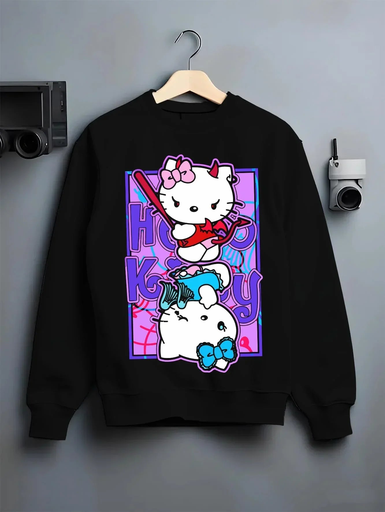 Black crewneck sweatshirt on hanger with Hello Kitty Hoodie Anime Inspired Cute Crossover Purple graphic bold anime graphic.