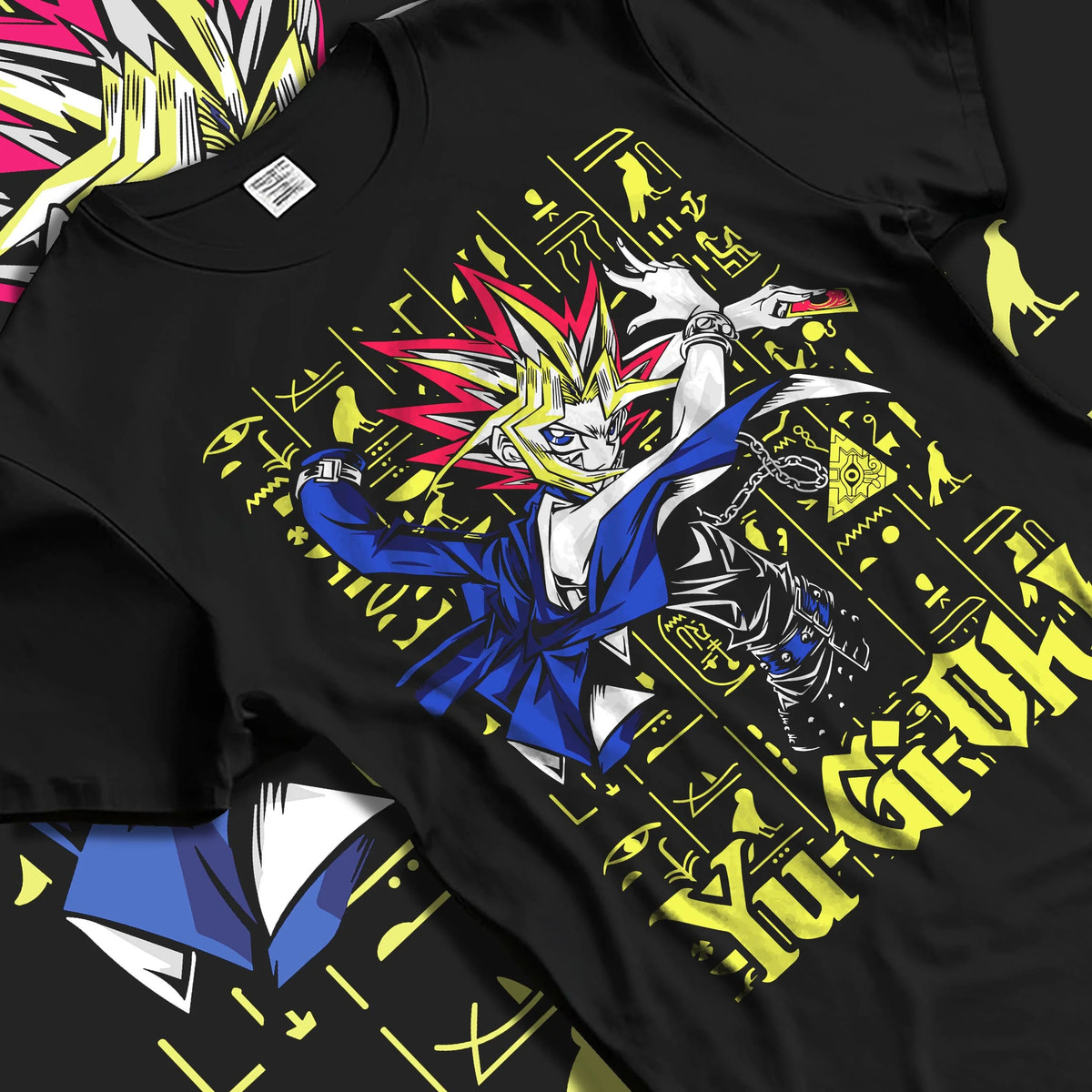 Black T-shirt laid flat with natural folds featuring Yugi King of Games Millennium Puzzle artwork.