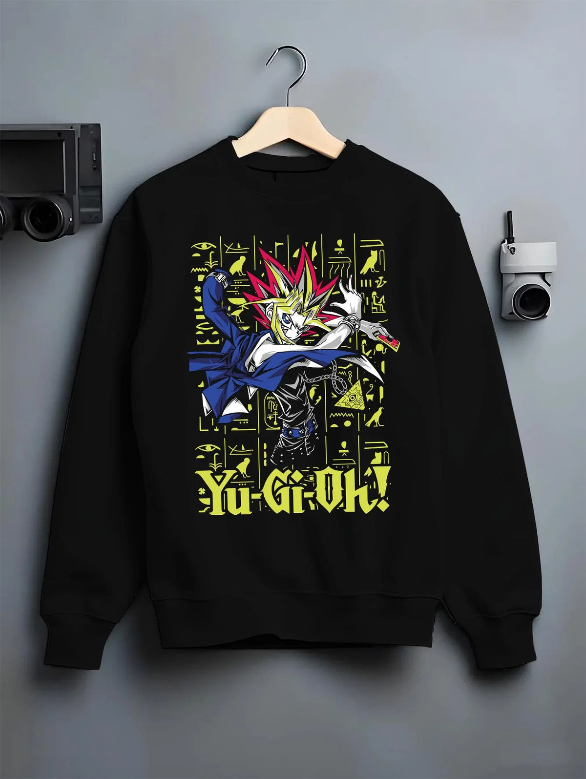 Black crewneck sweatshirt on hanger featuring Yugi King of Games Millennium Puzzle artwork.