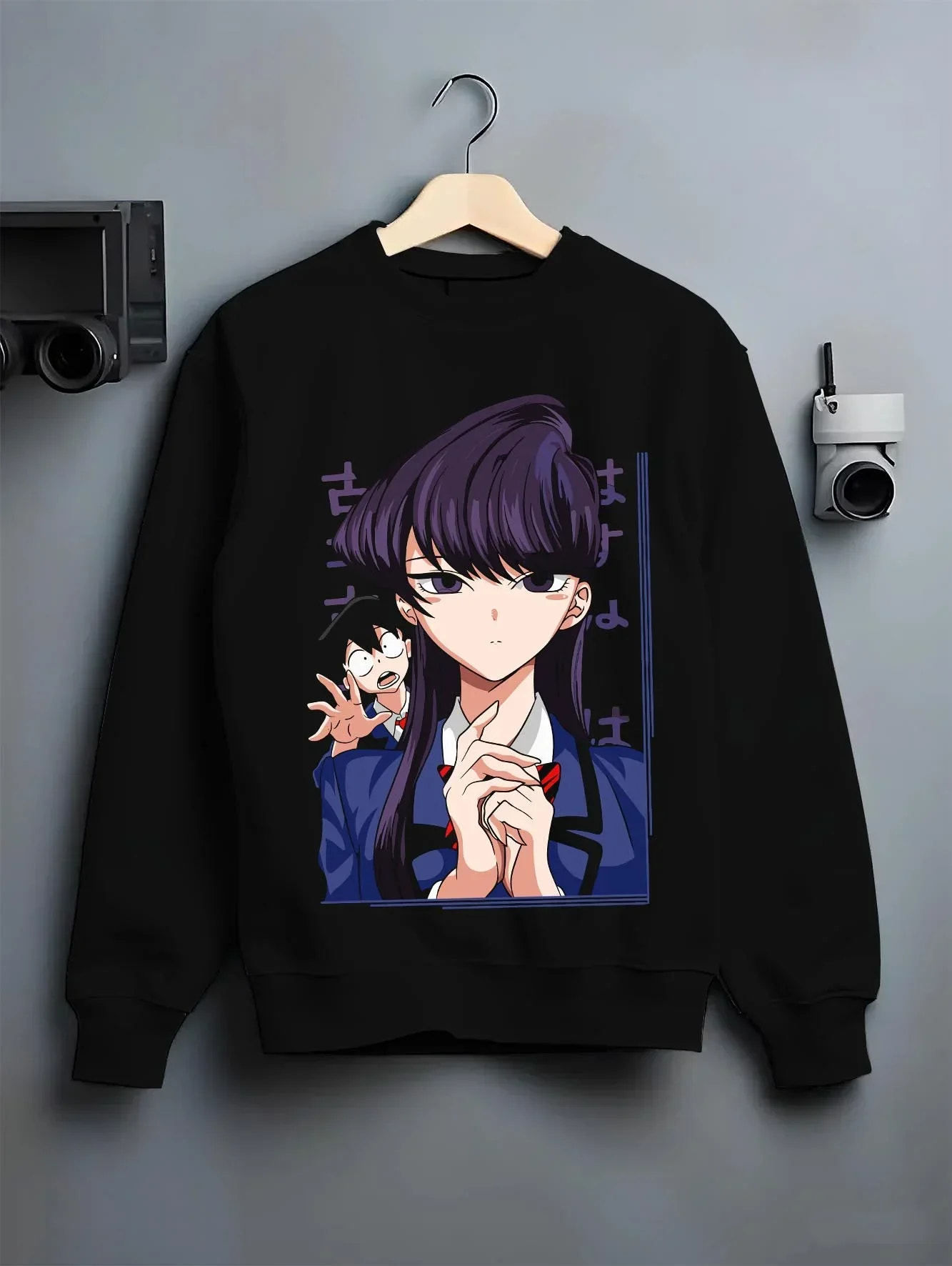 Black crewneck sweatshirt on hanger with Komi Can’t Communicate Hoodie Shouko Komi School Uniform graphic premium wear.