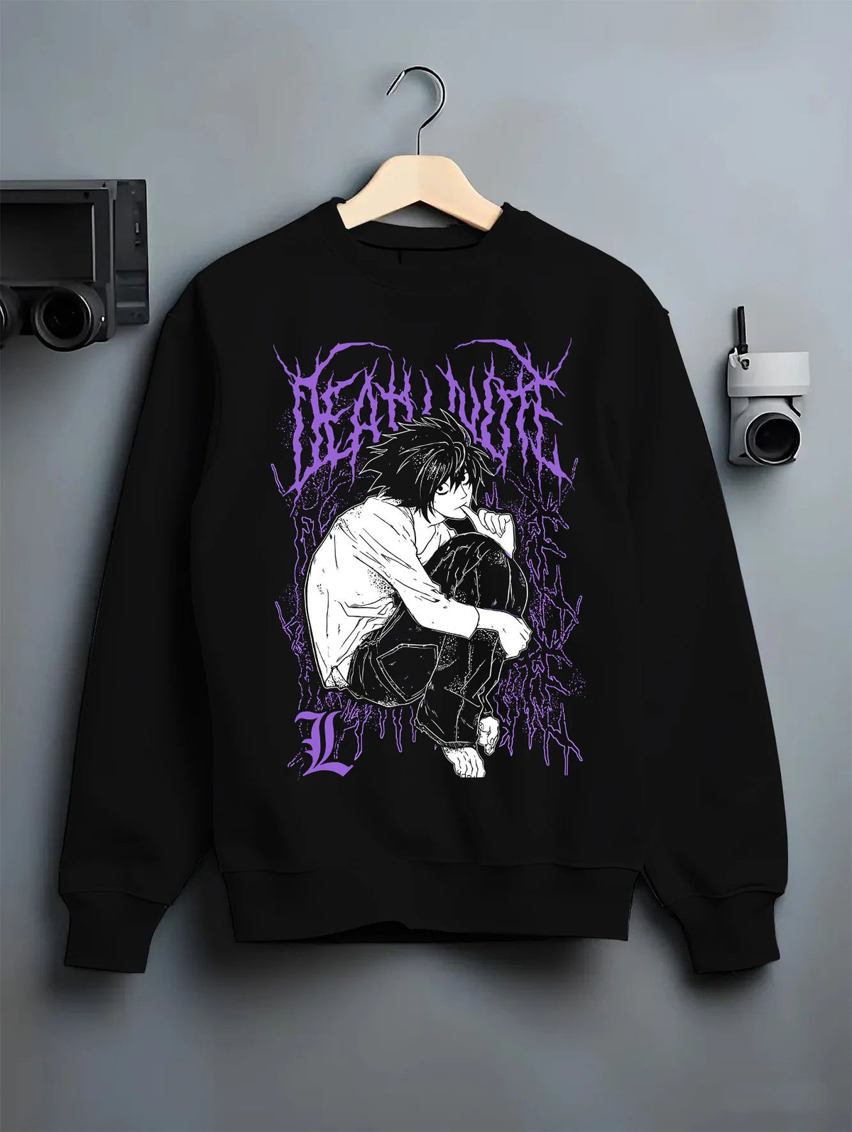 Black crewneck sweatshirt on hanger with L Lawliet crouching and thinking from Death Note illustrated back graphic