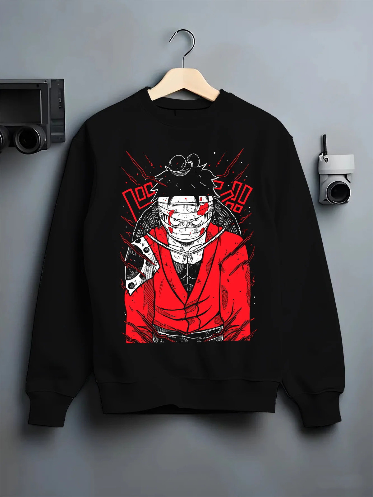 Black crewneck sweatshirt on hanger showing Monkey D. Luffy from One Piece: Straw Hat pirate red-black design