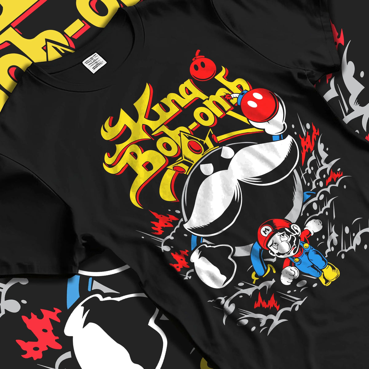 Black T-shirt laid flat with natural folds featuring Mario and King Bob-omb artwork.