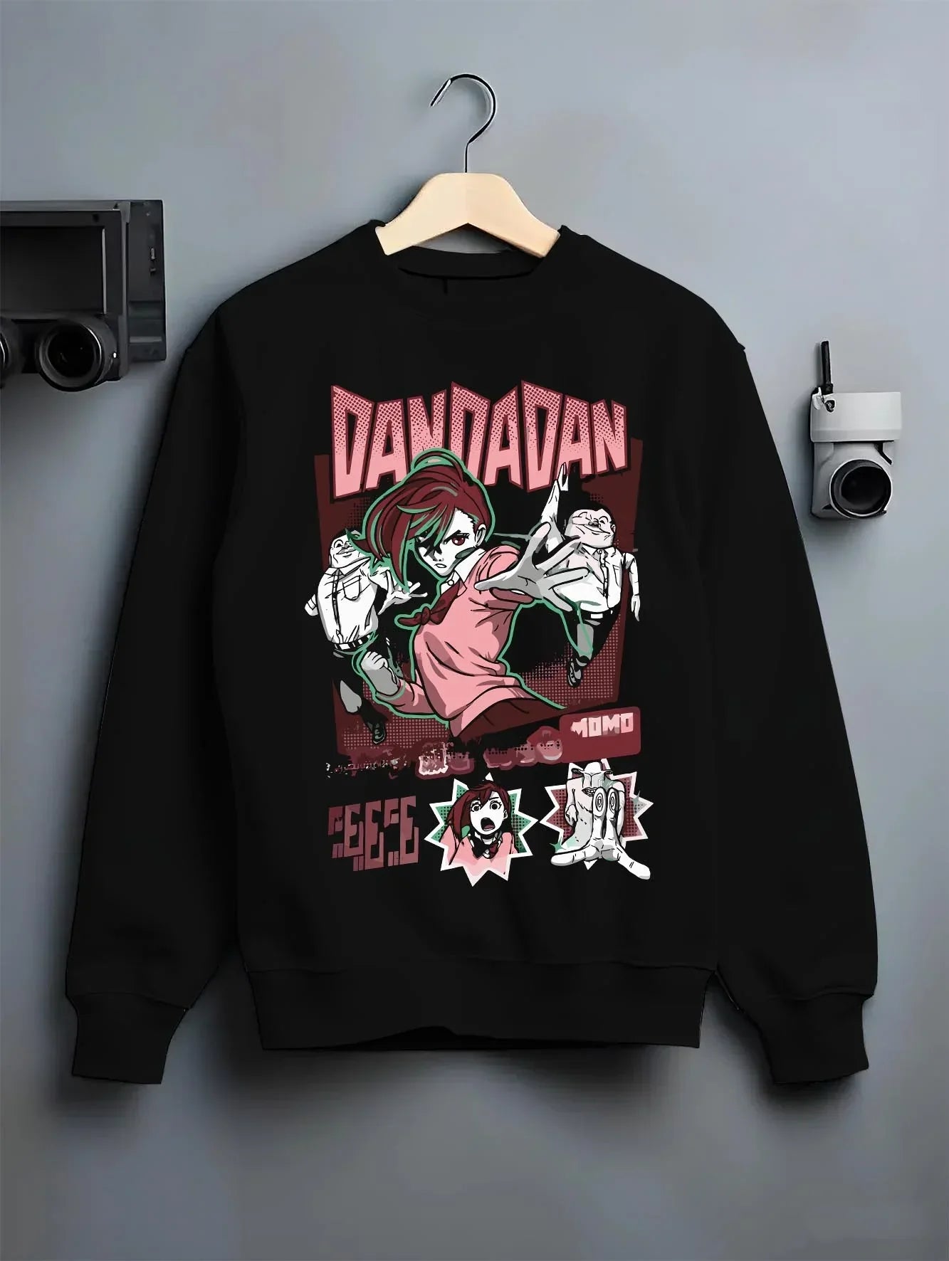 Black crewneck sweatshirt on hanger with Okarun Hoodie Dandadan Paranormal Spirit Battle graphic bold anime graphic.