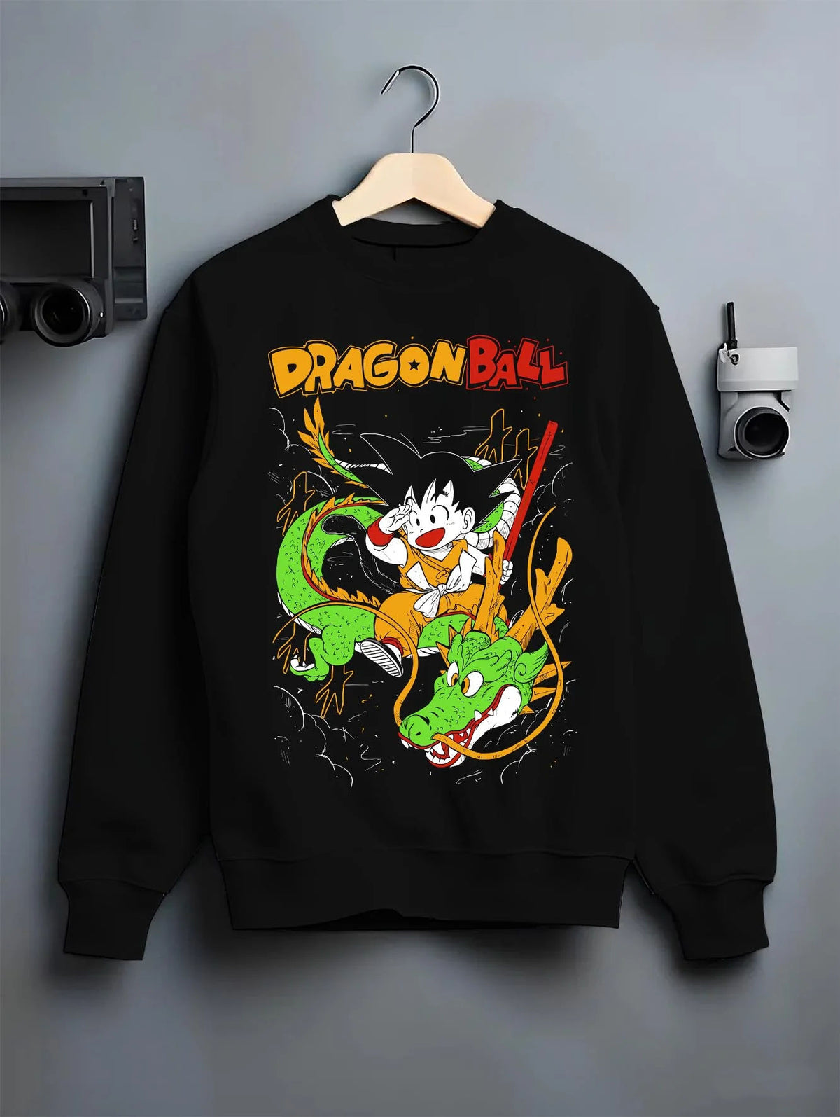 Black crewneck sweatshirt on hanger featuring Kid Goku and Shenron artwork.