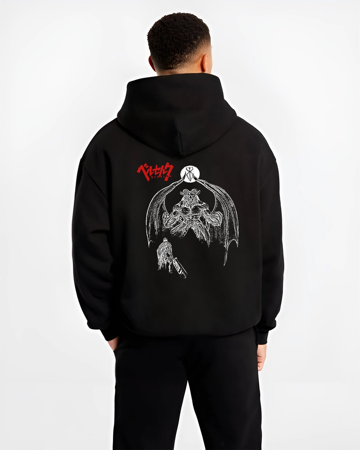 Black hoodie worn by a male model, back view, featuring Berserk Guts retro manga graphic with dark apostle figure and bold battle illustration.