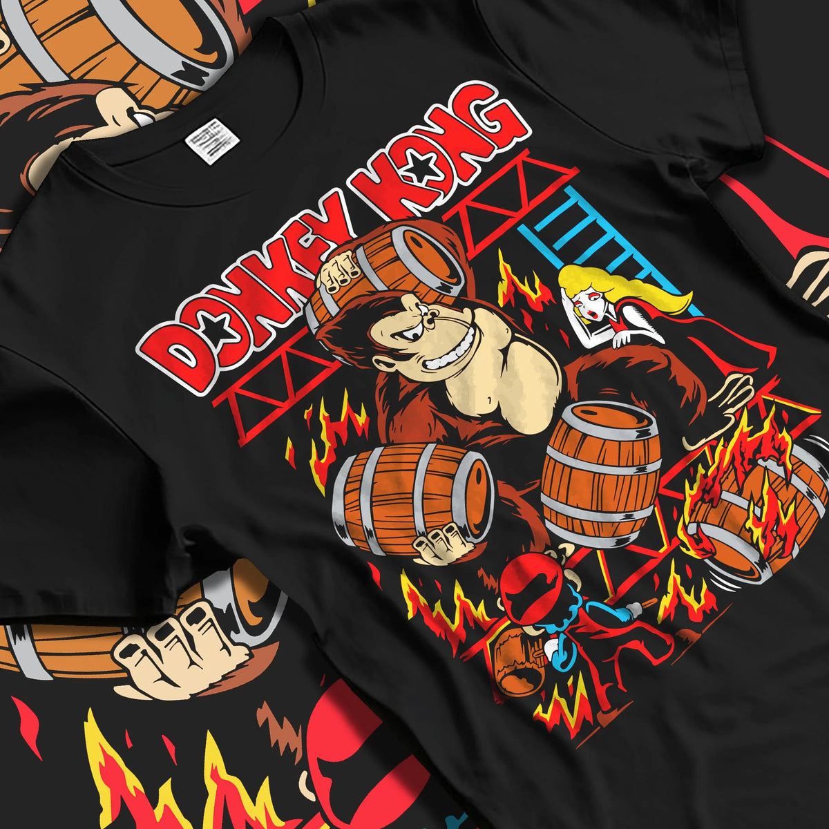 Black T-shirt laid flat with natural folds featuring Donkey Kong barrel throw artwork.