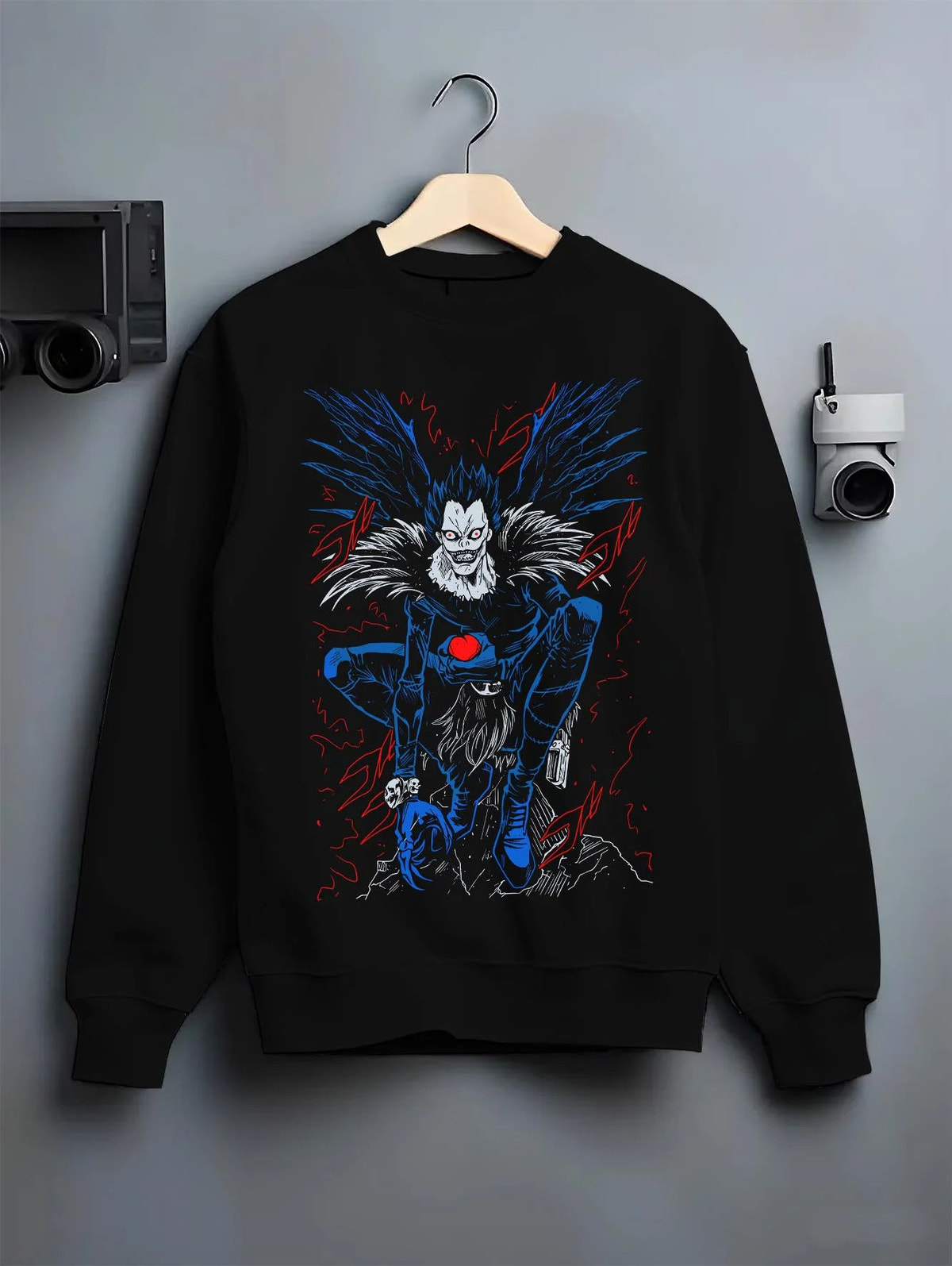 Black crewneck sweatshirt on hanger featuring Ryuk Shinigami apple Death Note artwork.