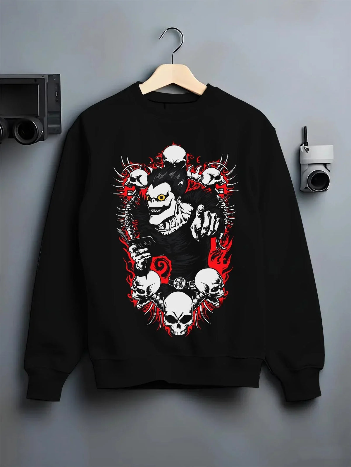 Black crewneck sweatshirt on hanger with Ryuk Hoodie Death Note Shinigami Apple Reaper Anime graphic premium wear.