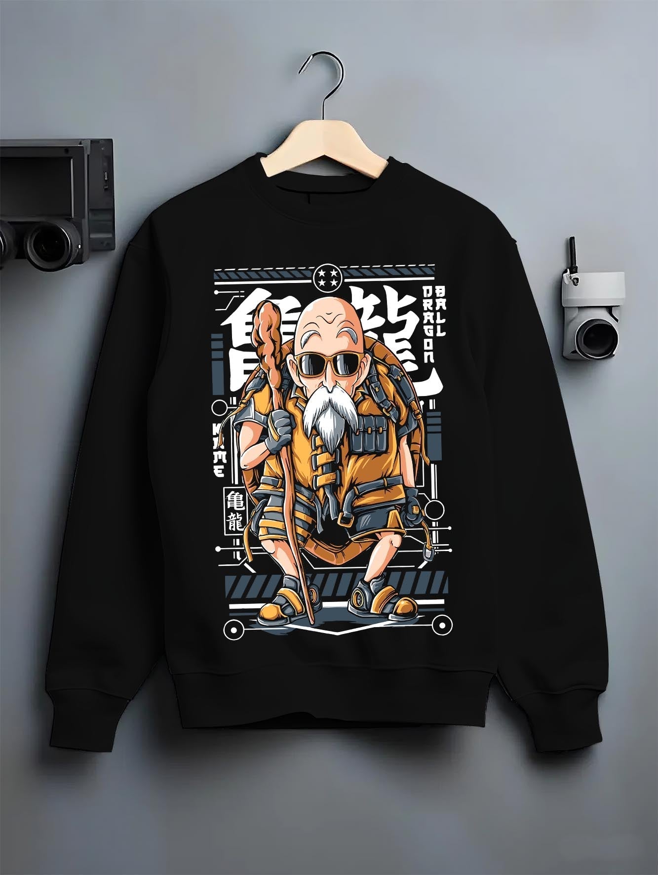Black crewneck sweatshirt on a hanger against a grey wall, featuring Dragon Ball Master Roshi anime poster inspired retro Japanese manga artwork.