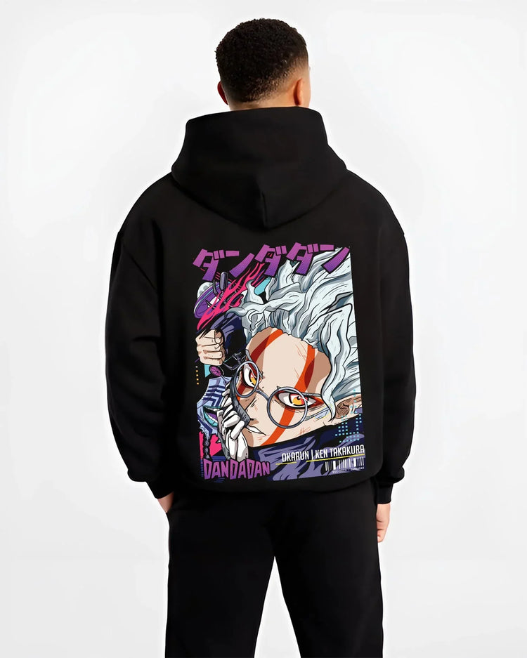 Black hoodie worn by male model, back view with Ken Takakura Hoodie Dandadan Dynamic Fight Scene graphic premium wear.