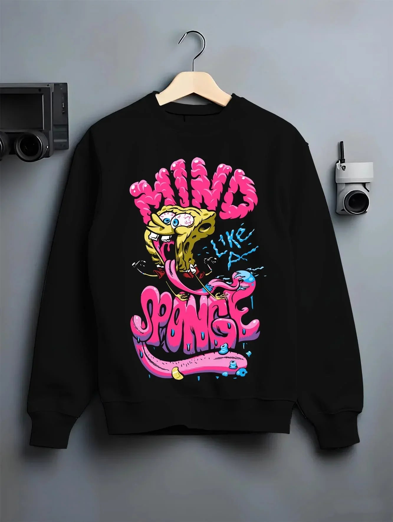 Black crewneck sweatshirt on hanger with SpongeBob Hoodie Mind Sponge Cartoon Retro Parody graphic streetwear graphic.