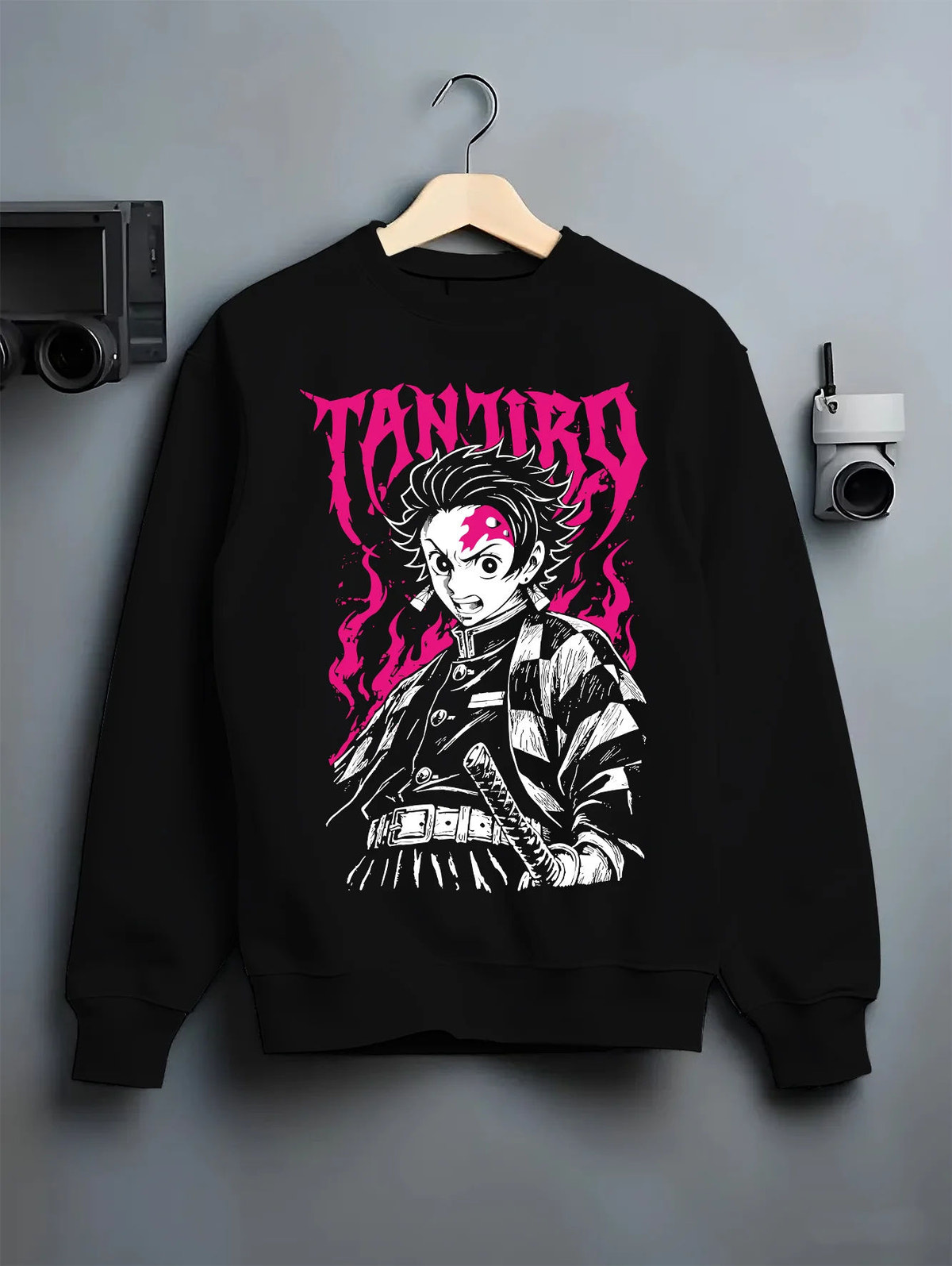Black crewneck sweatshirt on hanger showing Tanjiro Kamado from Demon Slayer: katana monochrome and magenta
