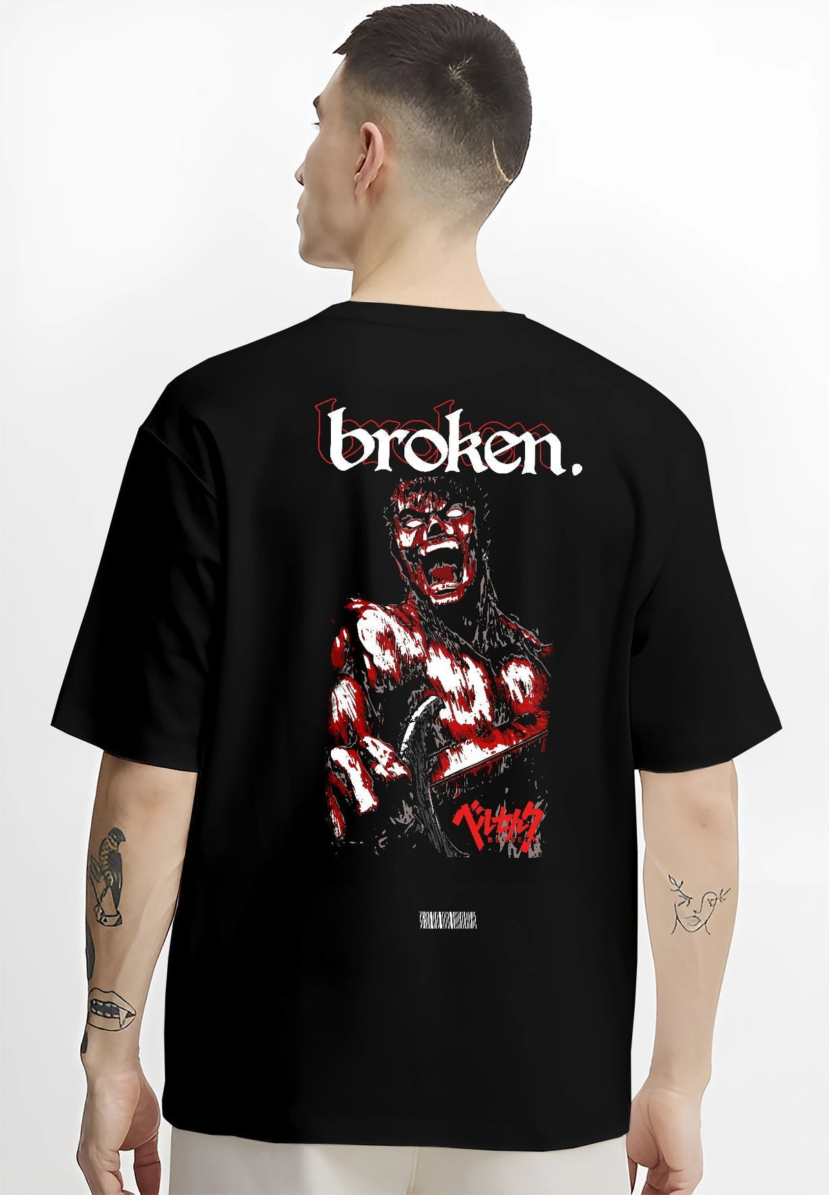 Black T-shirt worn by a male model, back view, featuring Berserk Guts Japanese animation streetwear graphic with gritty bloody manga artwork and bold “broken” text.