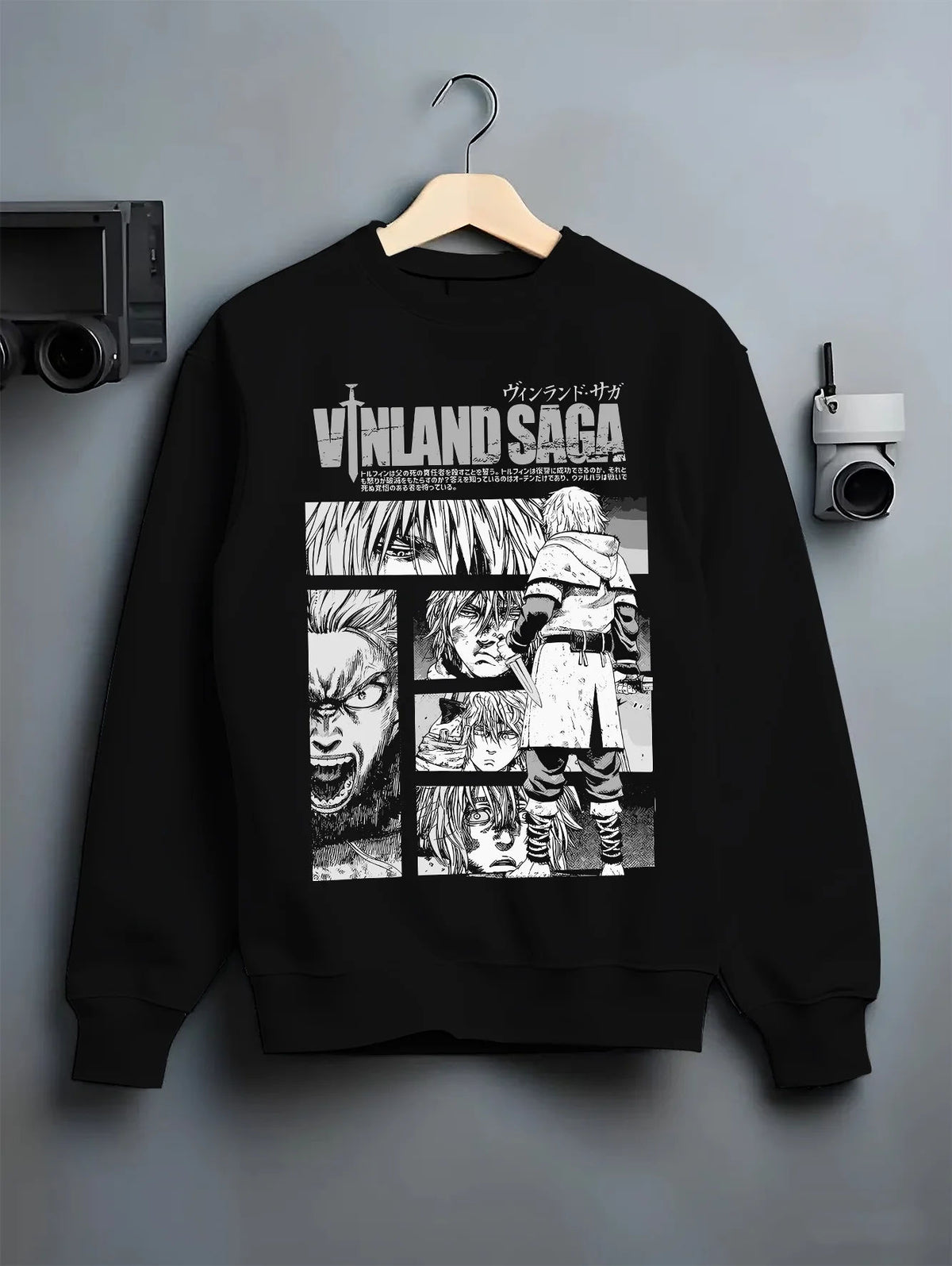 Black crewneck sweatshirt on hanger showing Vinland Saga: black-and-white character collage