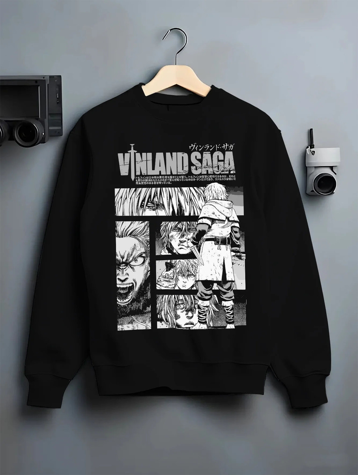 Black crewneck sweatshirt on hanger showing Vinland Saga: black-and-white character collage